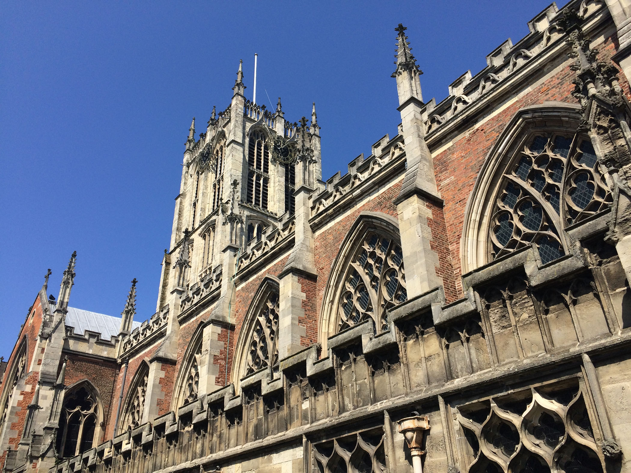 Looking up at church clock tower from the side of the building