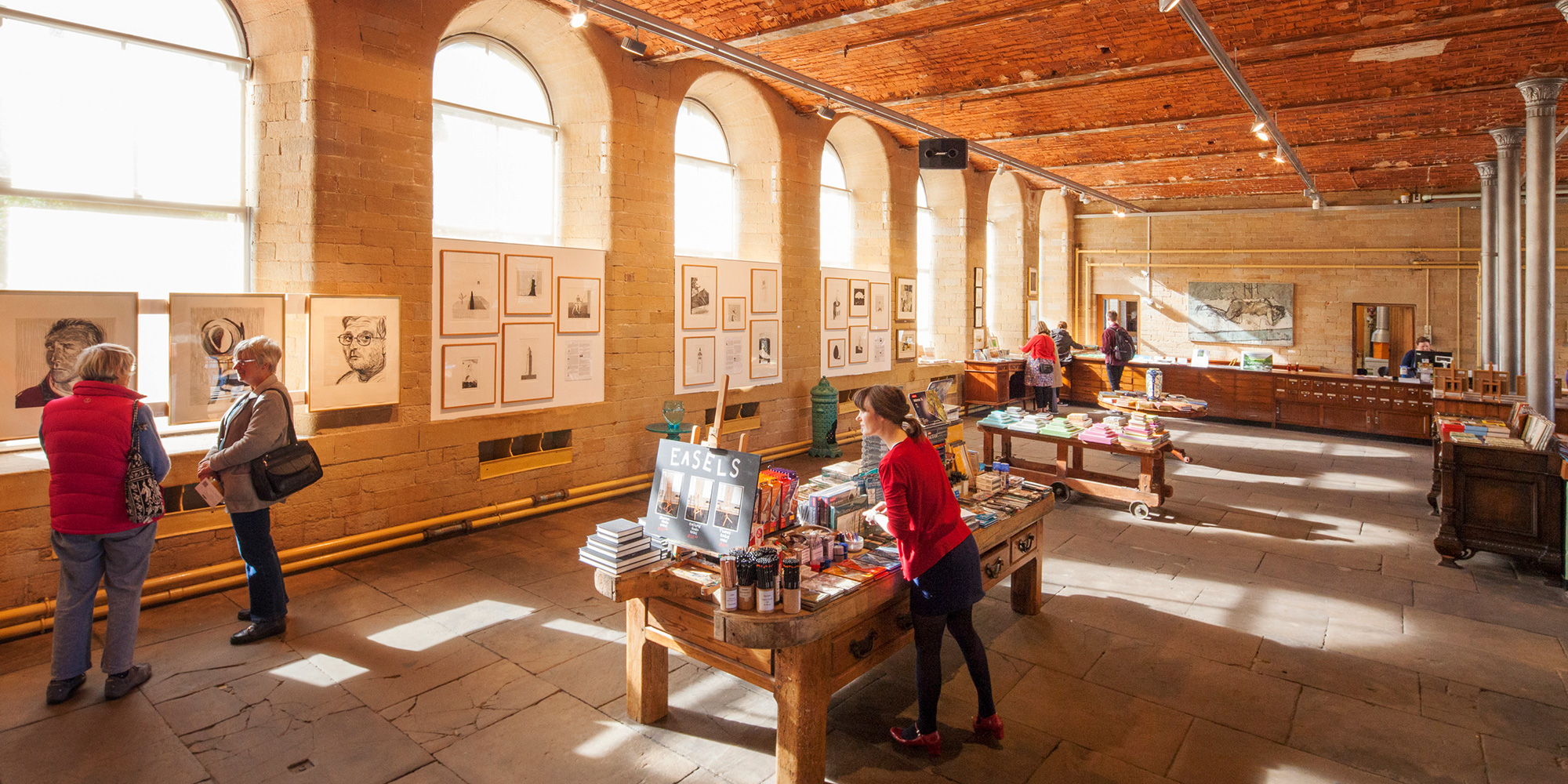 A young woman investigates goods on sale at a gift shop in a repurposed industrial building.
