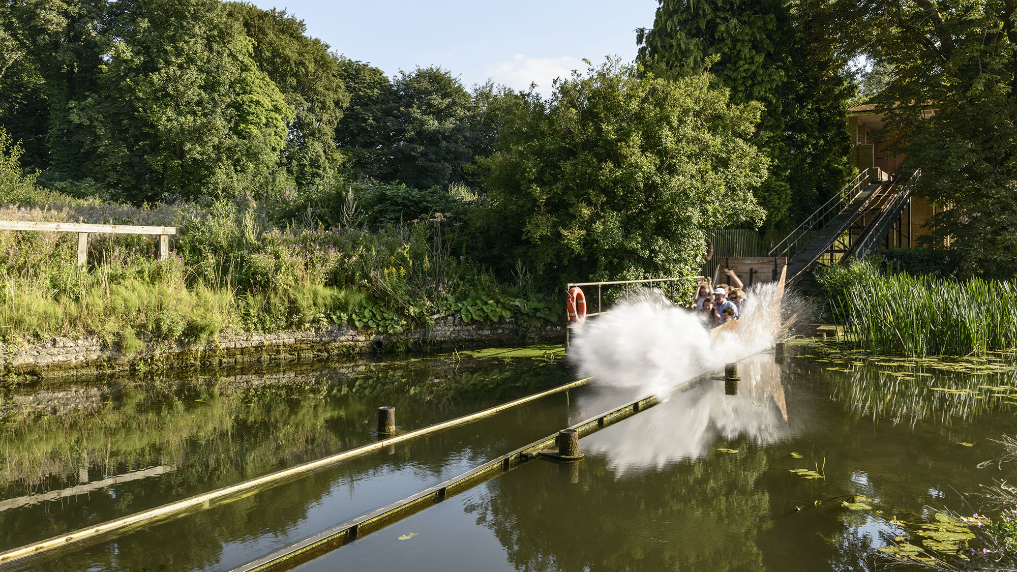 Water Chute at Wicksteed Park as a cart and its occupants hurtle into the water creating a huge splash.