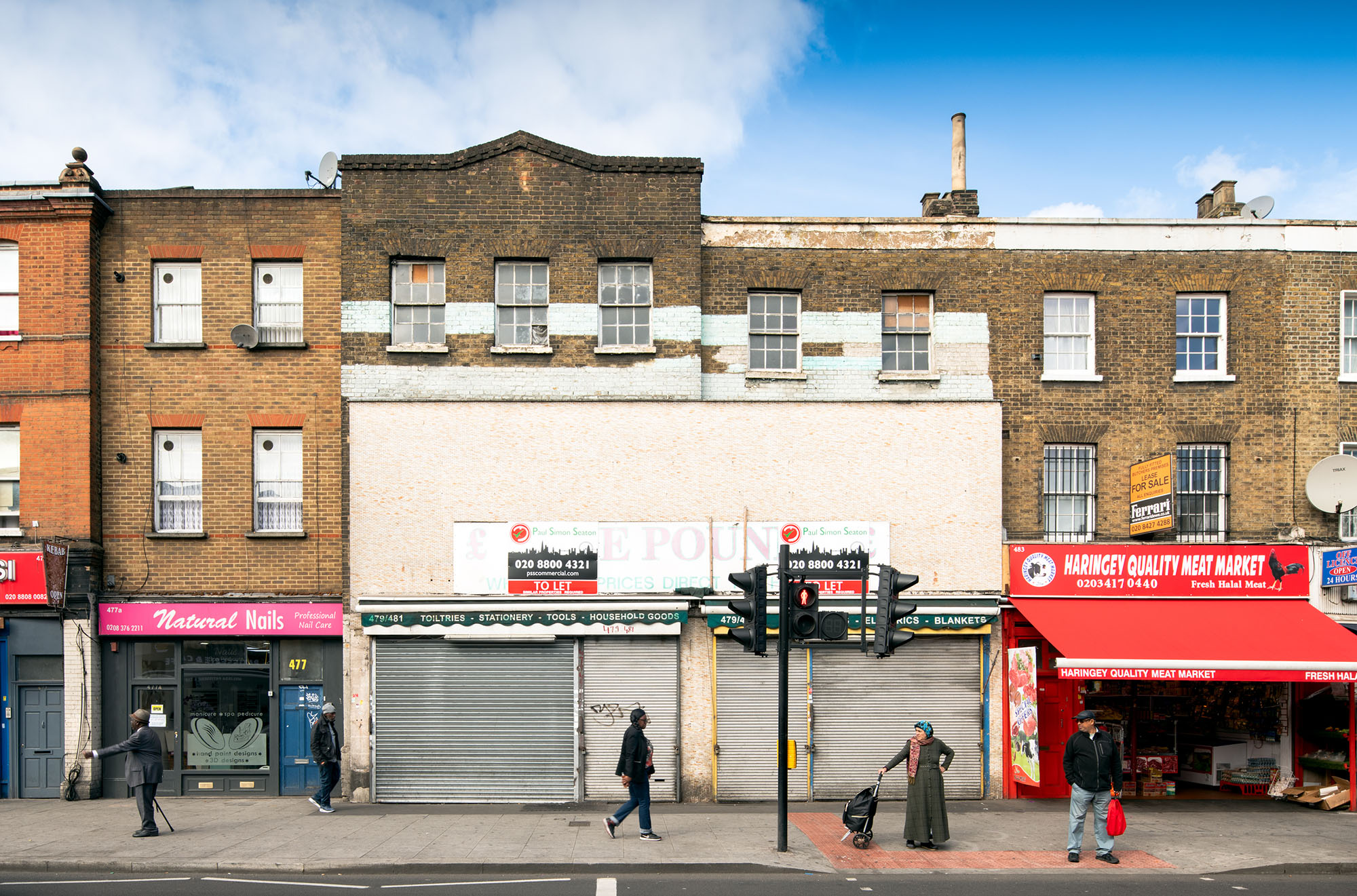 People walking passed derelict shop on high street