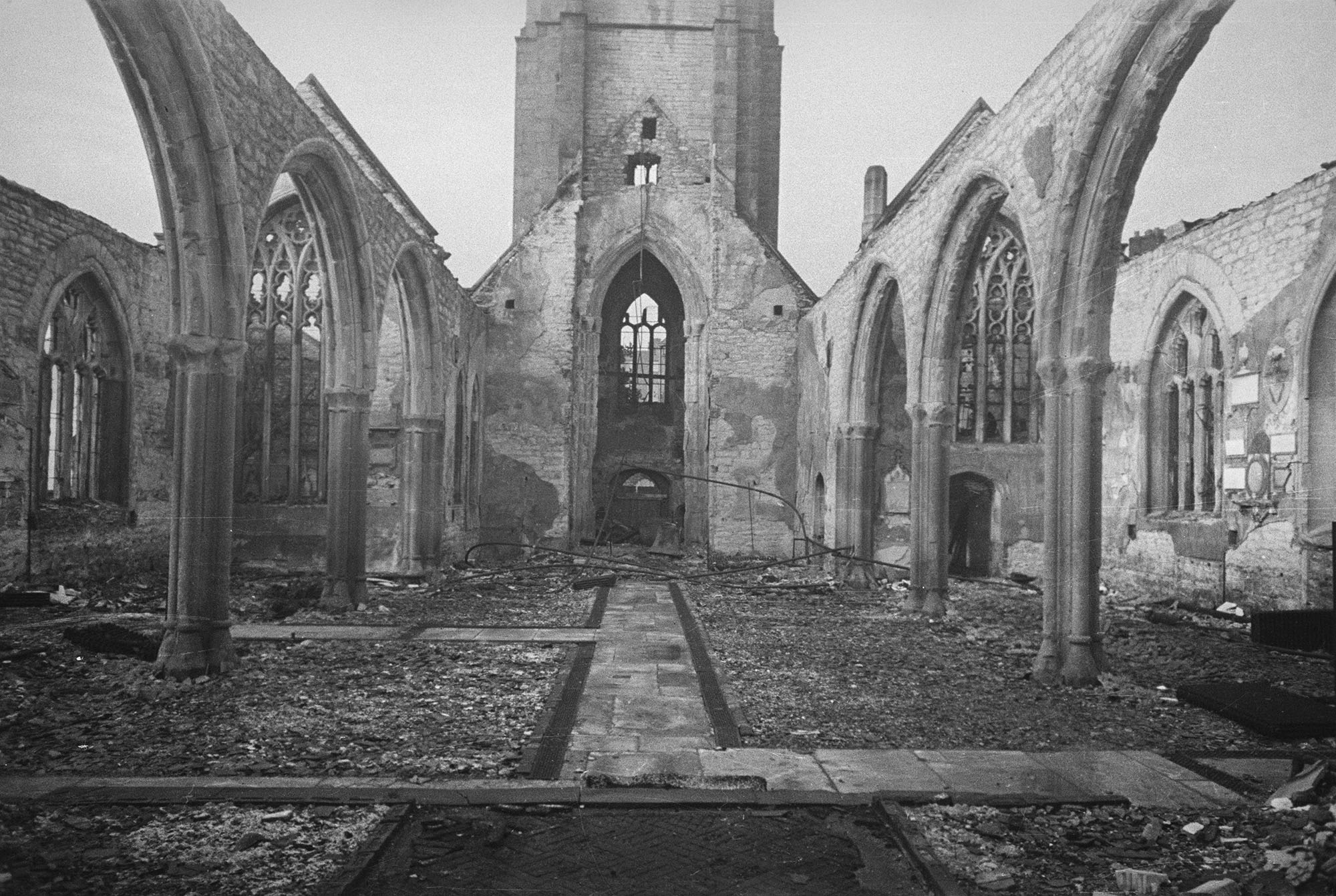 Interior of the nave looking towards the church tower with no roof or windows or interior furnishings.