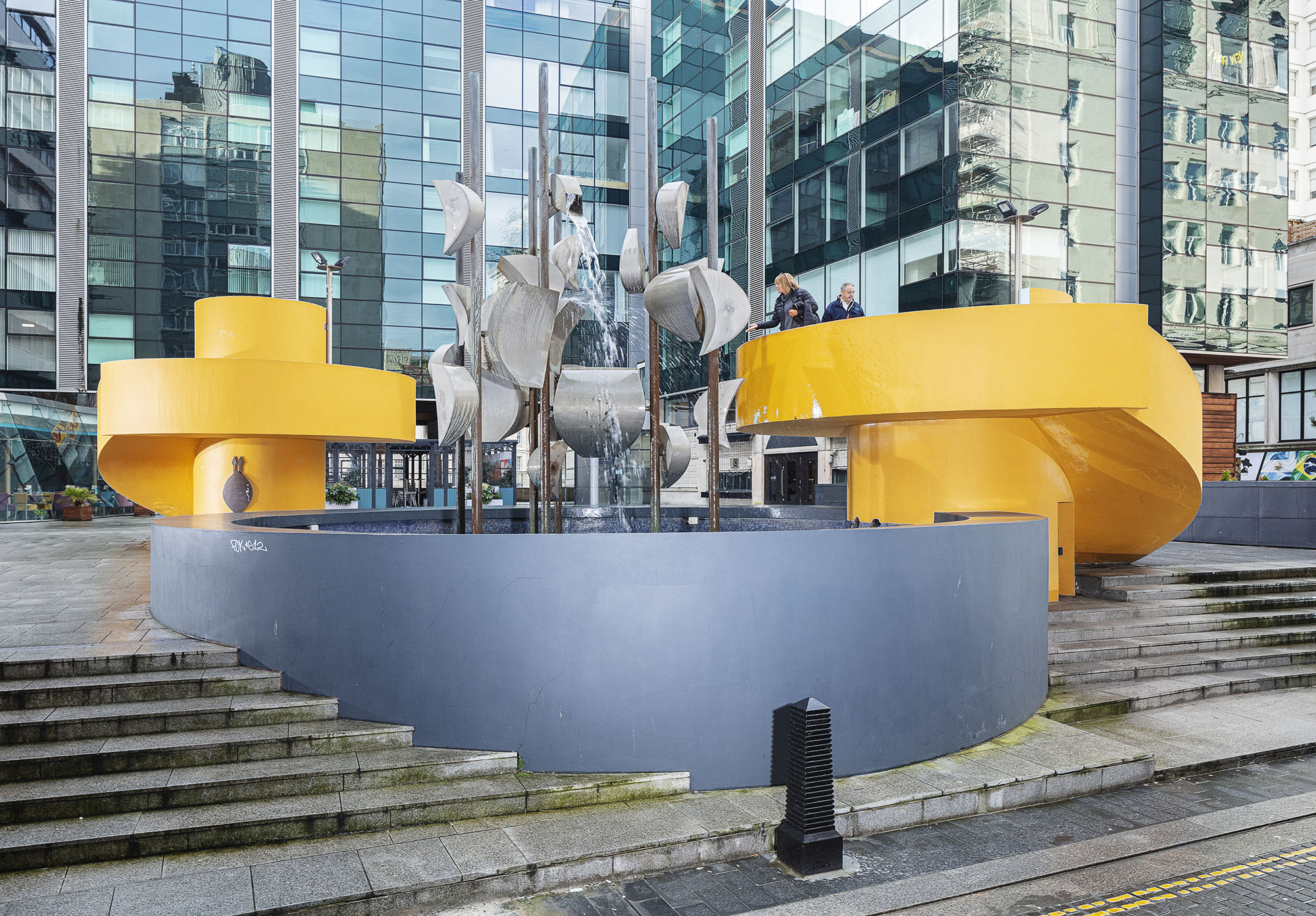 Sculpture set within steps up to modern building in the background