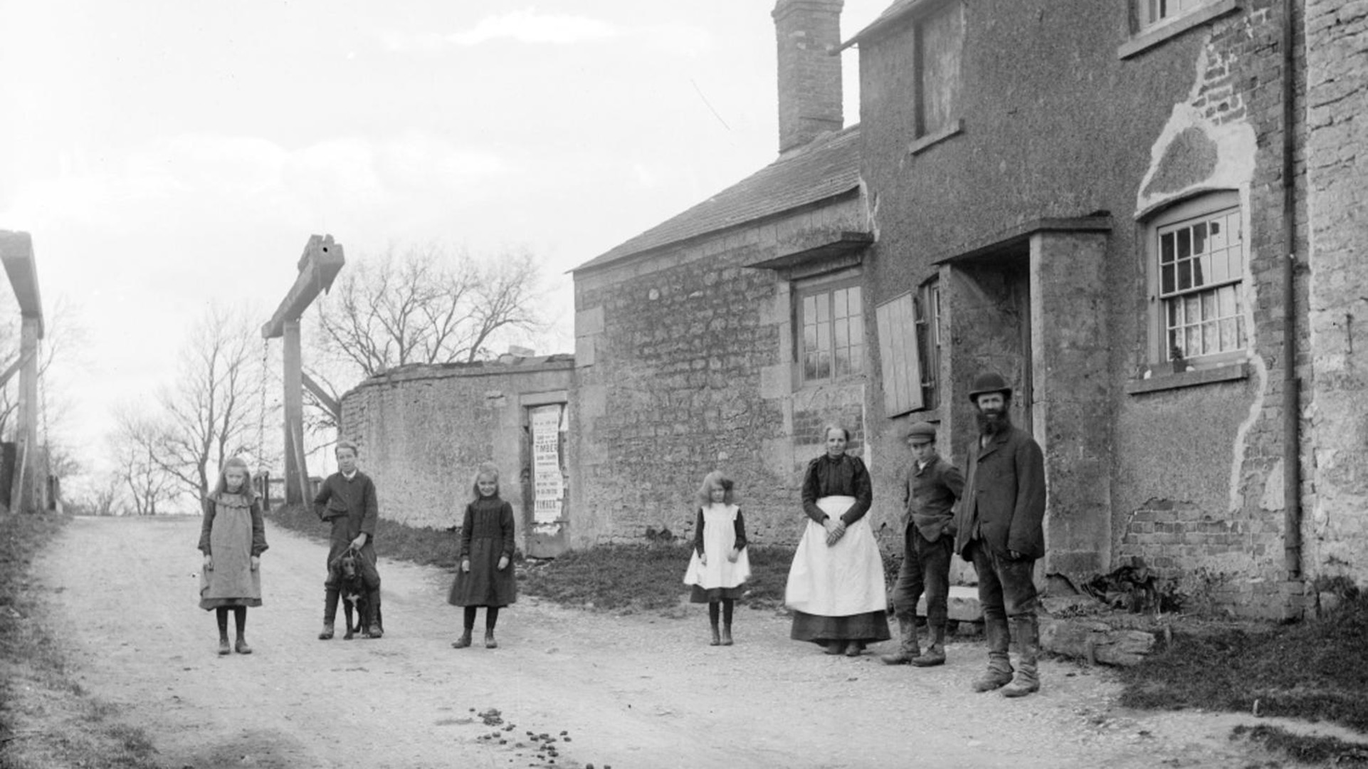 A family group standing outside their cottage