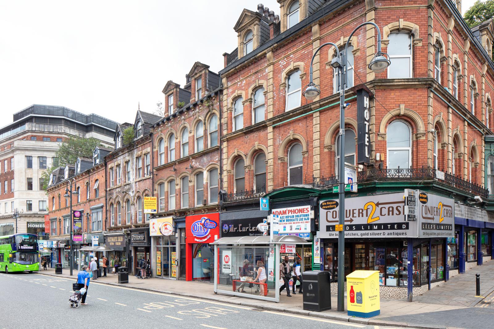 High street with people waiting at a bus stop