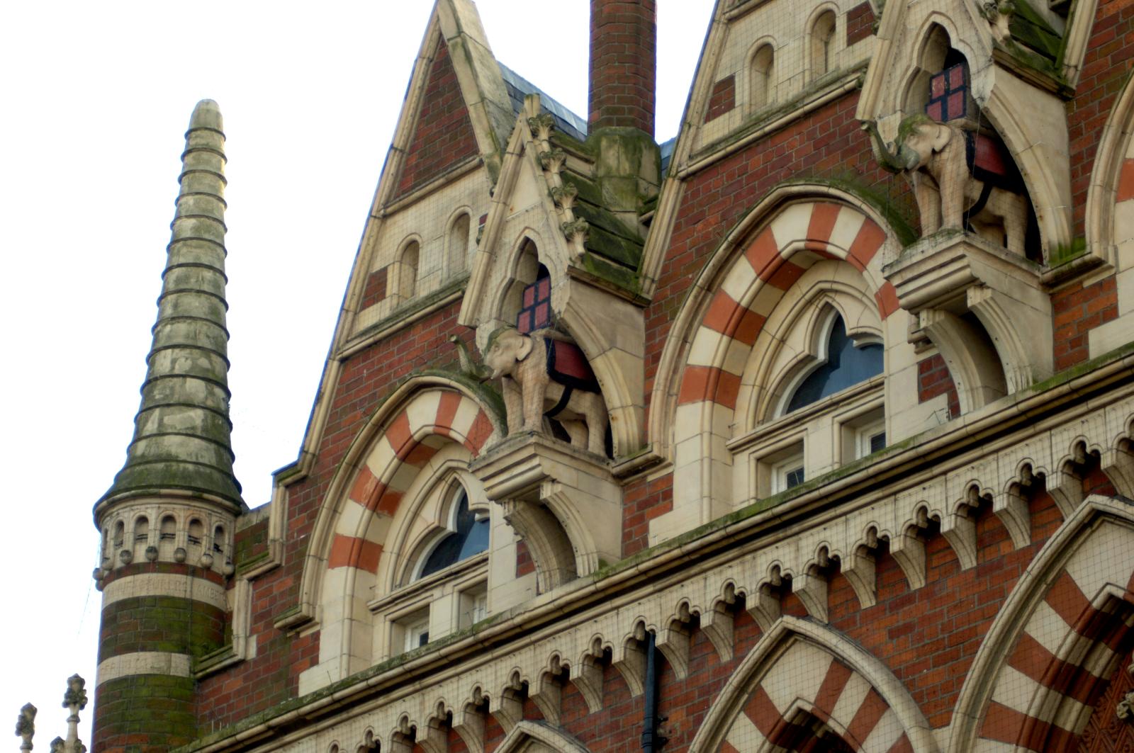 Carving of two elephants on the side of a building.