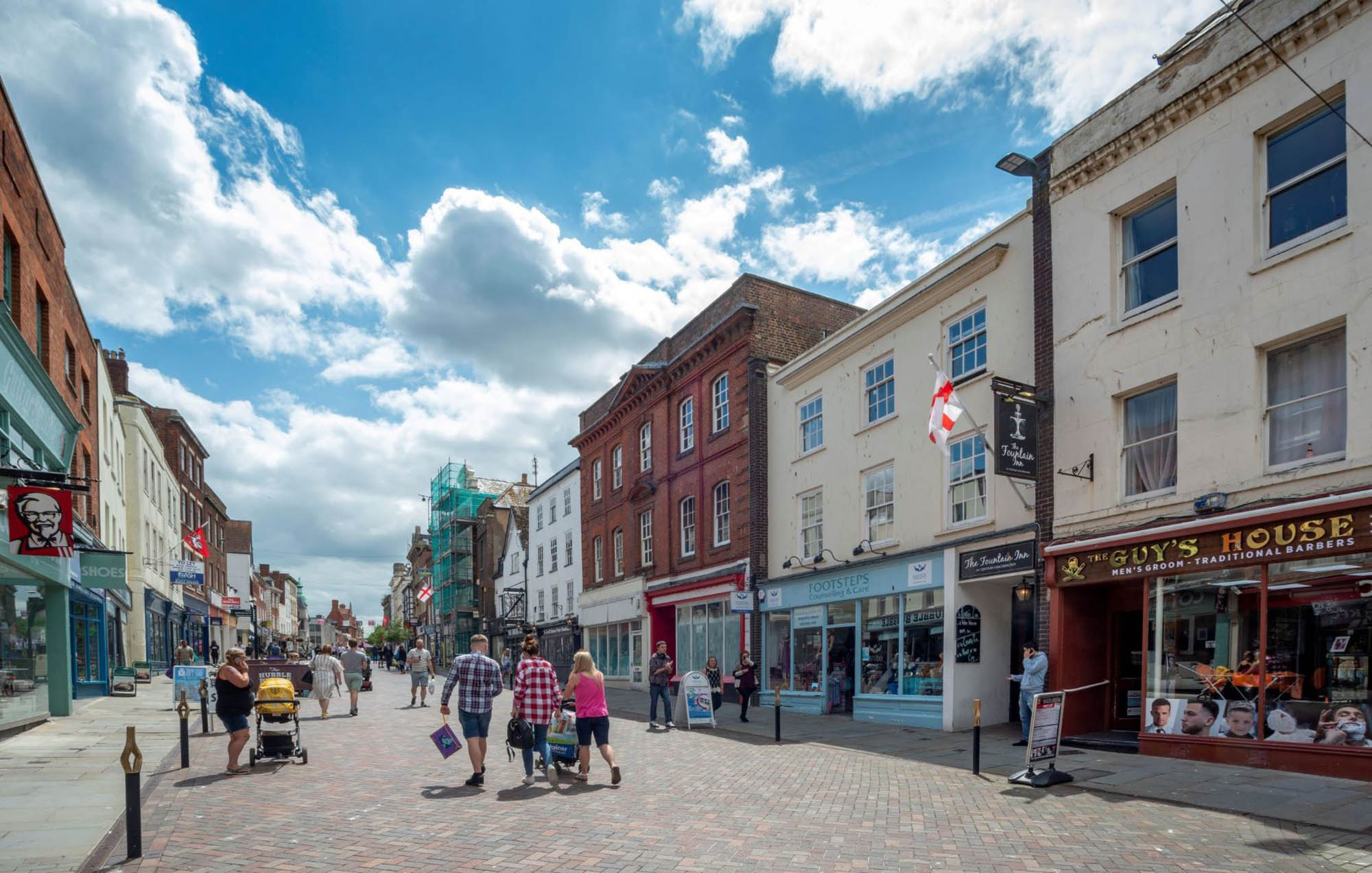 People walking down a pedestrianised high street on a sunny day