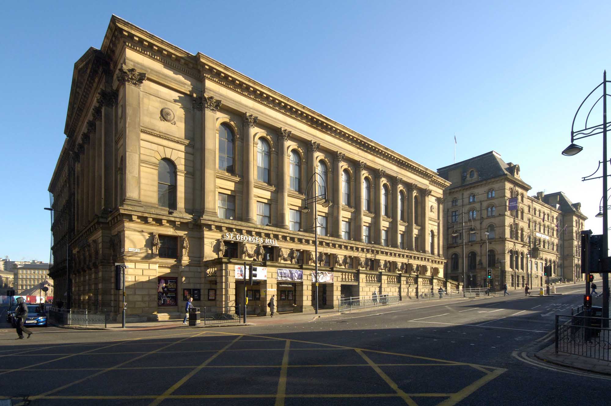 Front and side elevation of a large sand coloured rectangular building. 