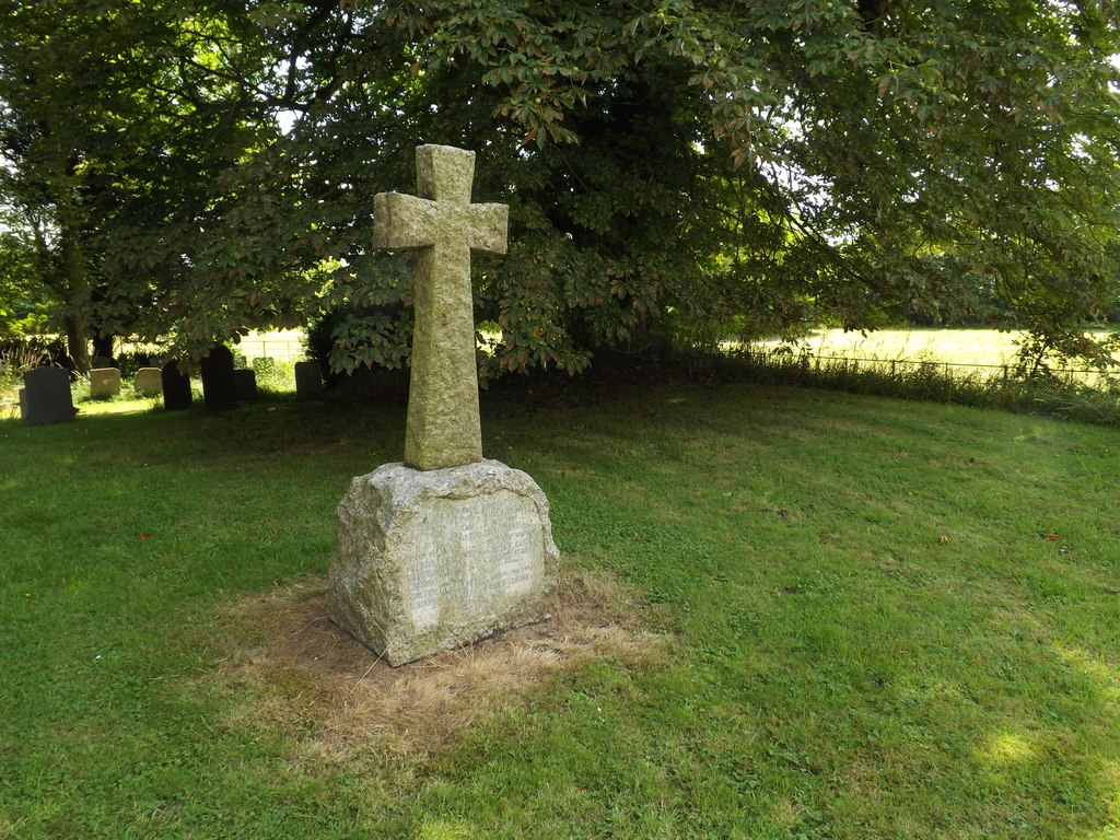 Stone crucifix standing on a rough carved rock with one face engraved with names of members of the local cummunity who lost their lives in the First World War.