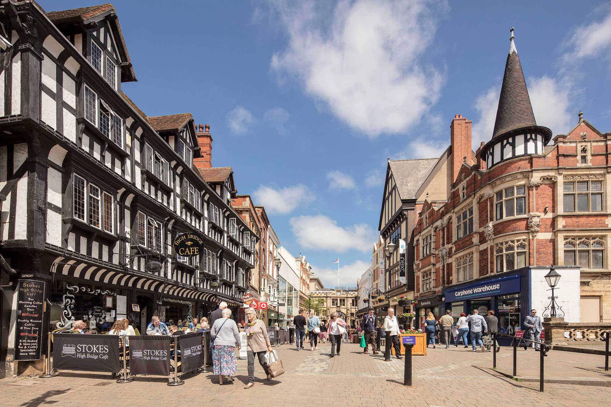 Shoppers in a historic high street setting.