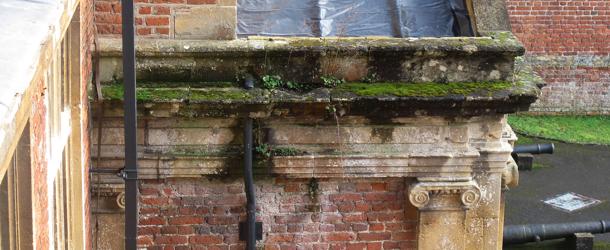 stone and brick building. The stone in particular is showing signs of deterioration caused by dampness and water penetration