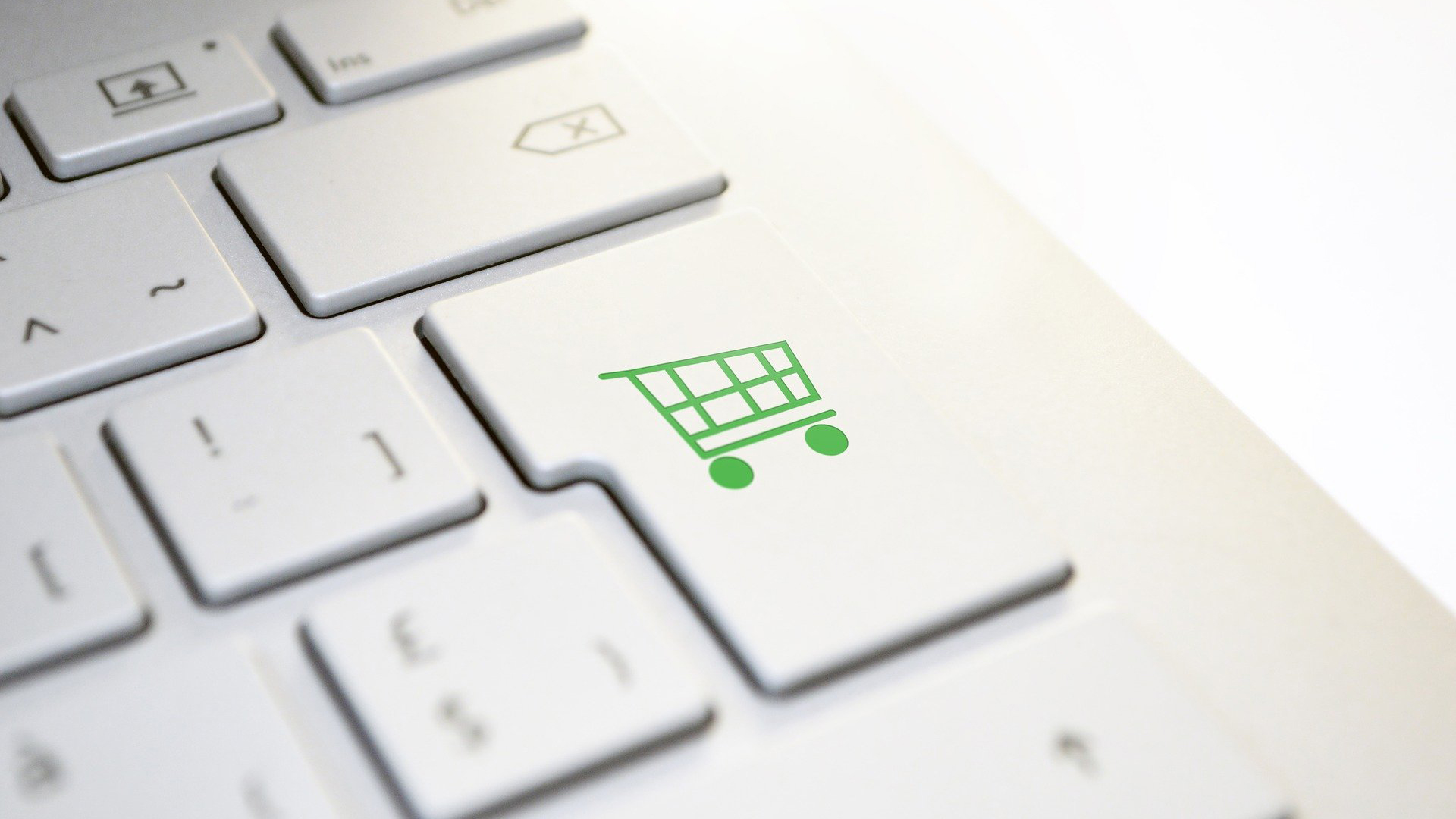 Computer keyboard with a shopping cart on one of the keys