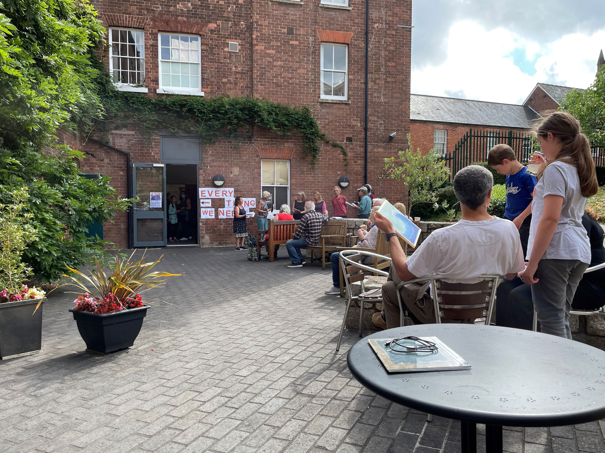 A group of people seated outside a historic building whilst working on a wellbeing project.
