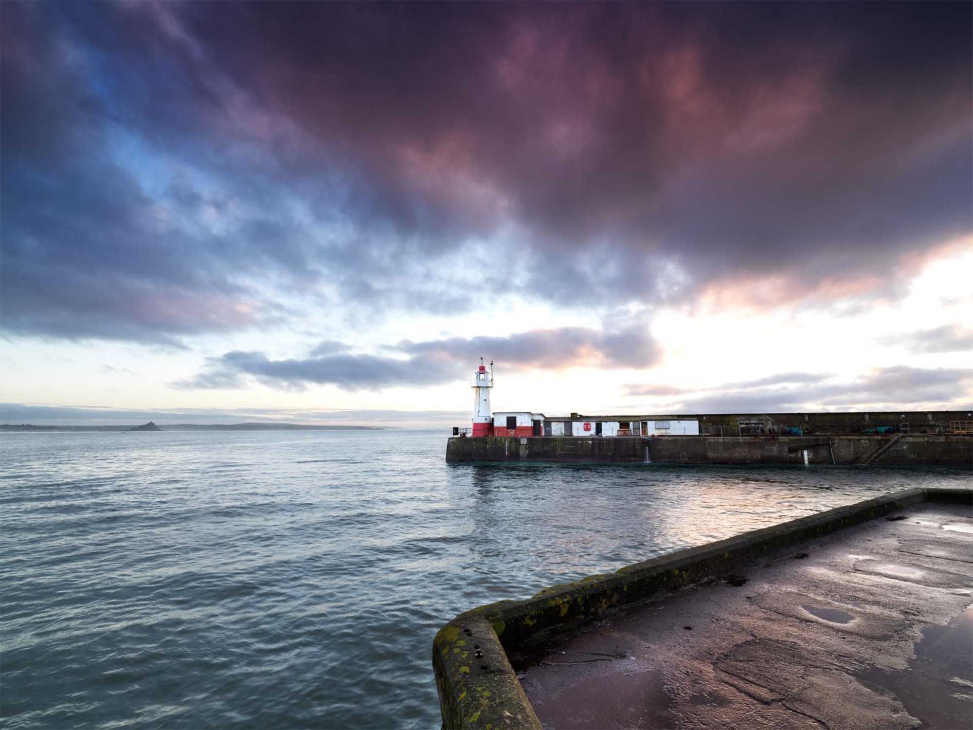 Lighthouse at the end of a pier surrounded by water