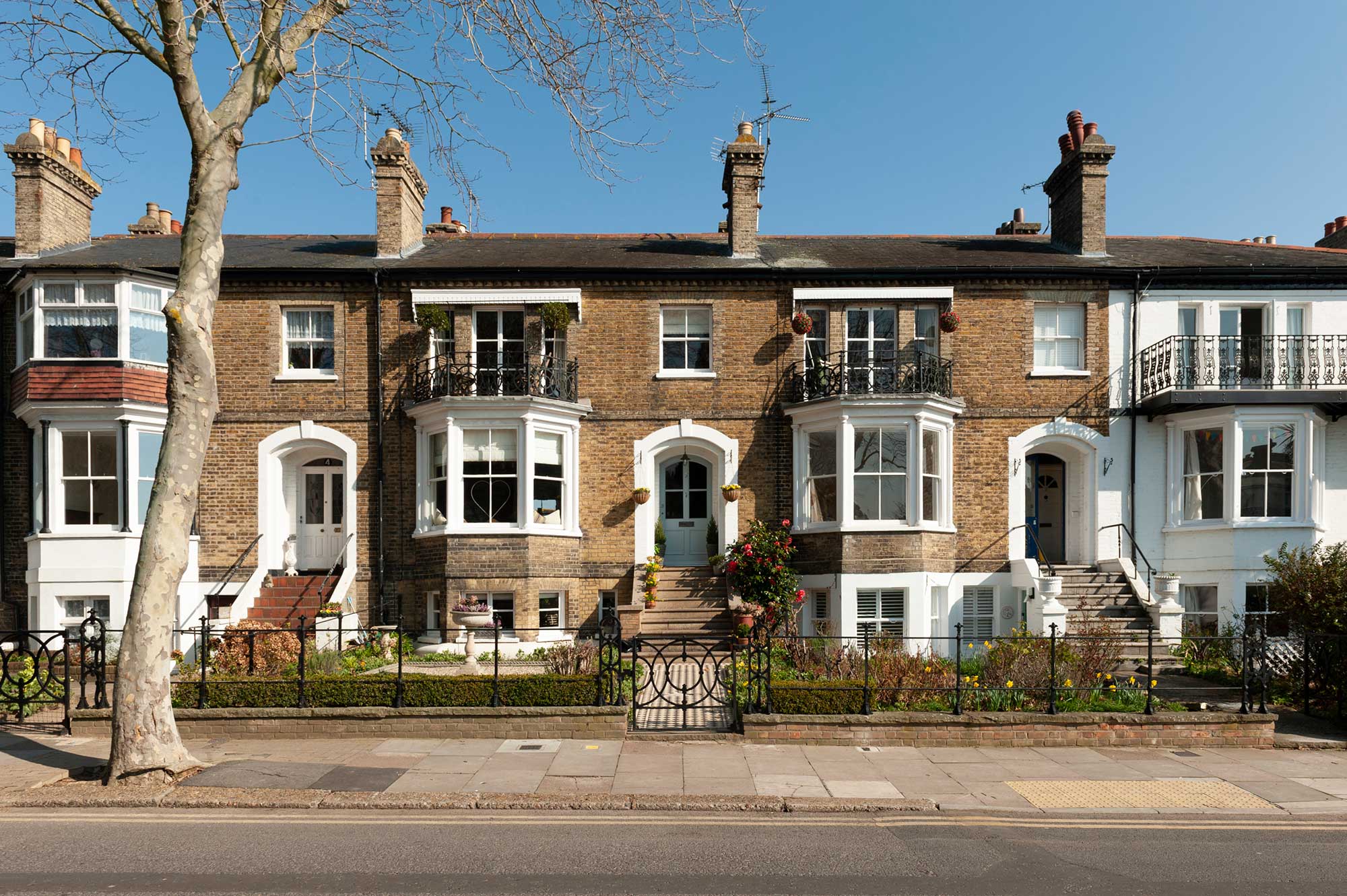 Terraced houses with bay sash windows on the ground floor and balconies above.