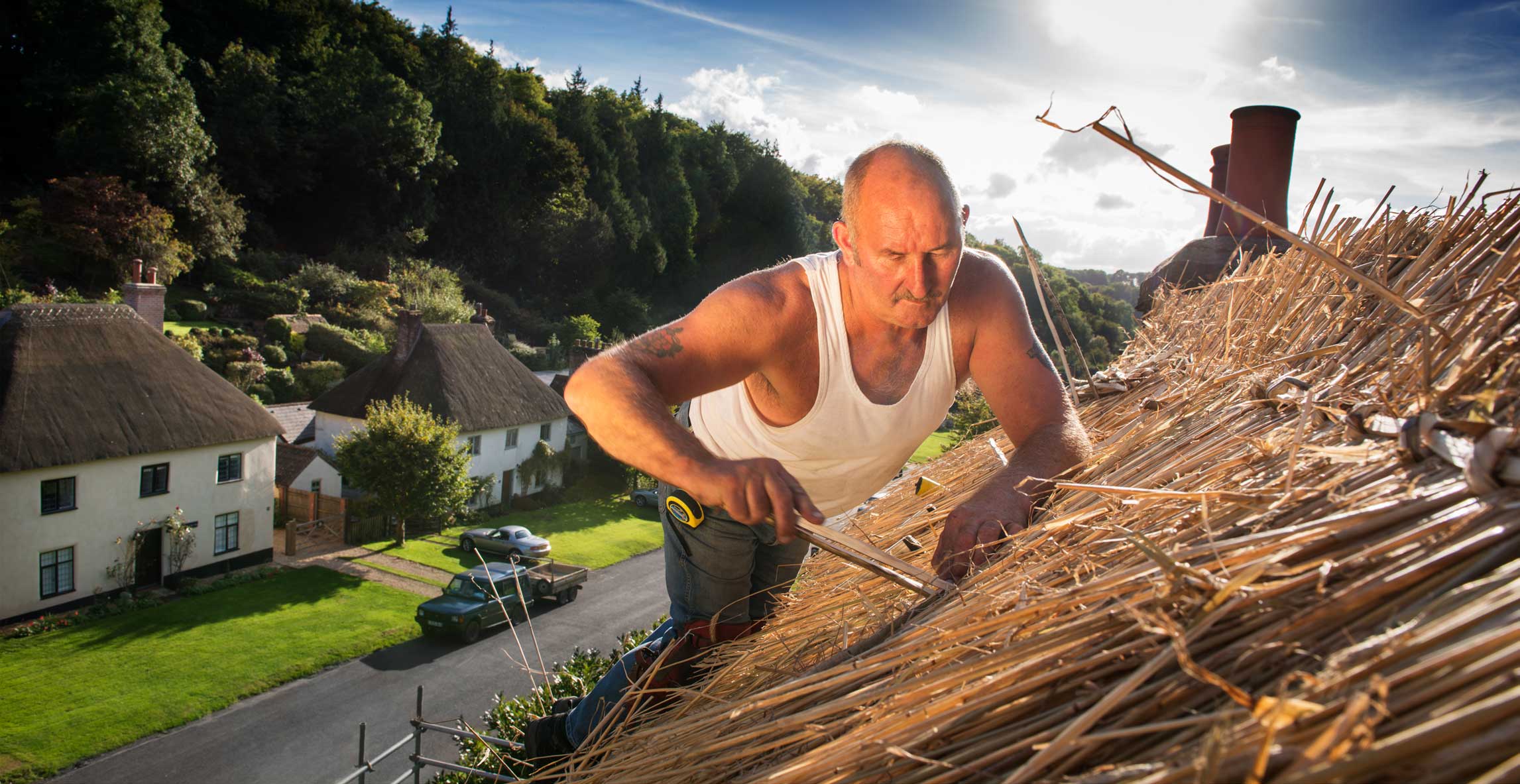 A thatcher working on a roof.