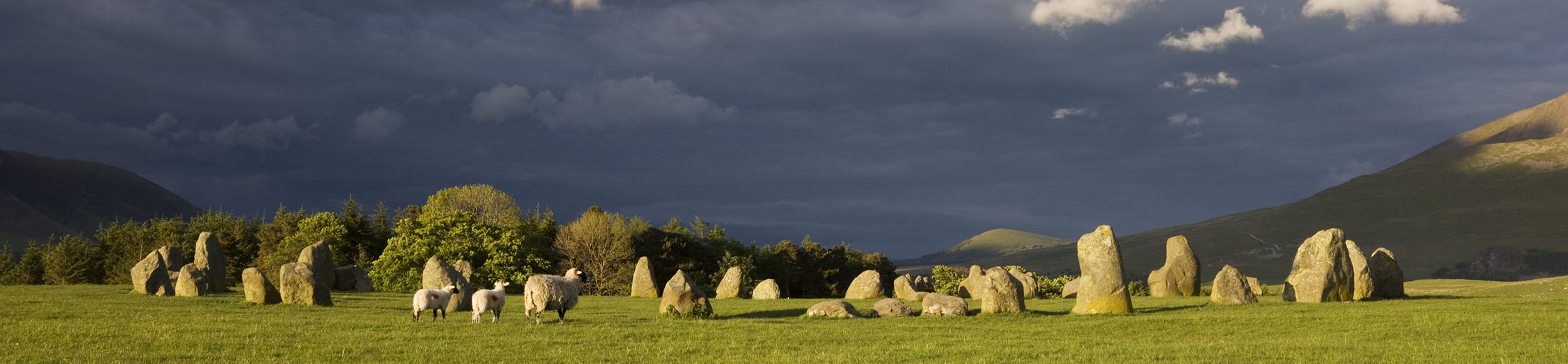 The prehistoric stone circle at Castlerigg with dark skies in the background