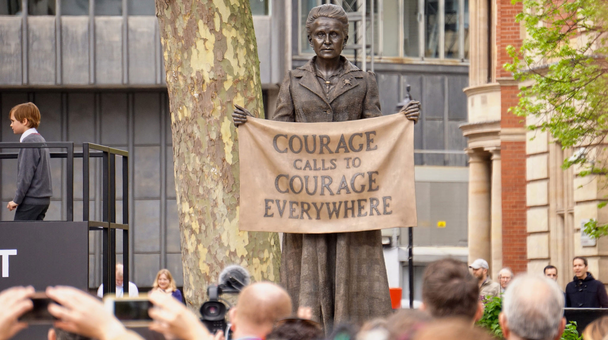 Statue of Millicent Fawcett holding a banner that displays text:
"Courage calls to courage everywhere"