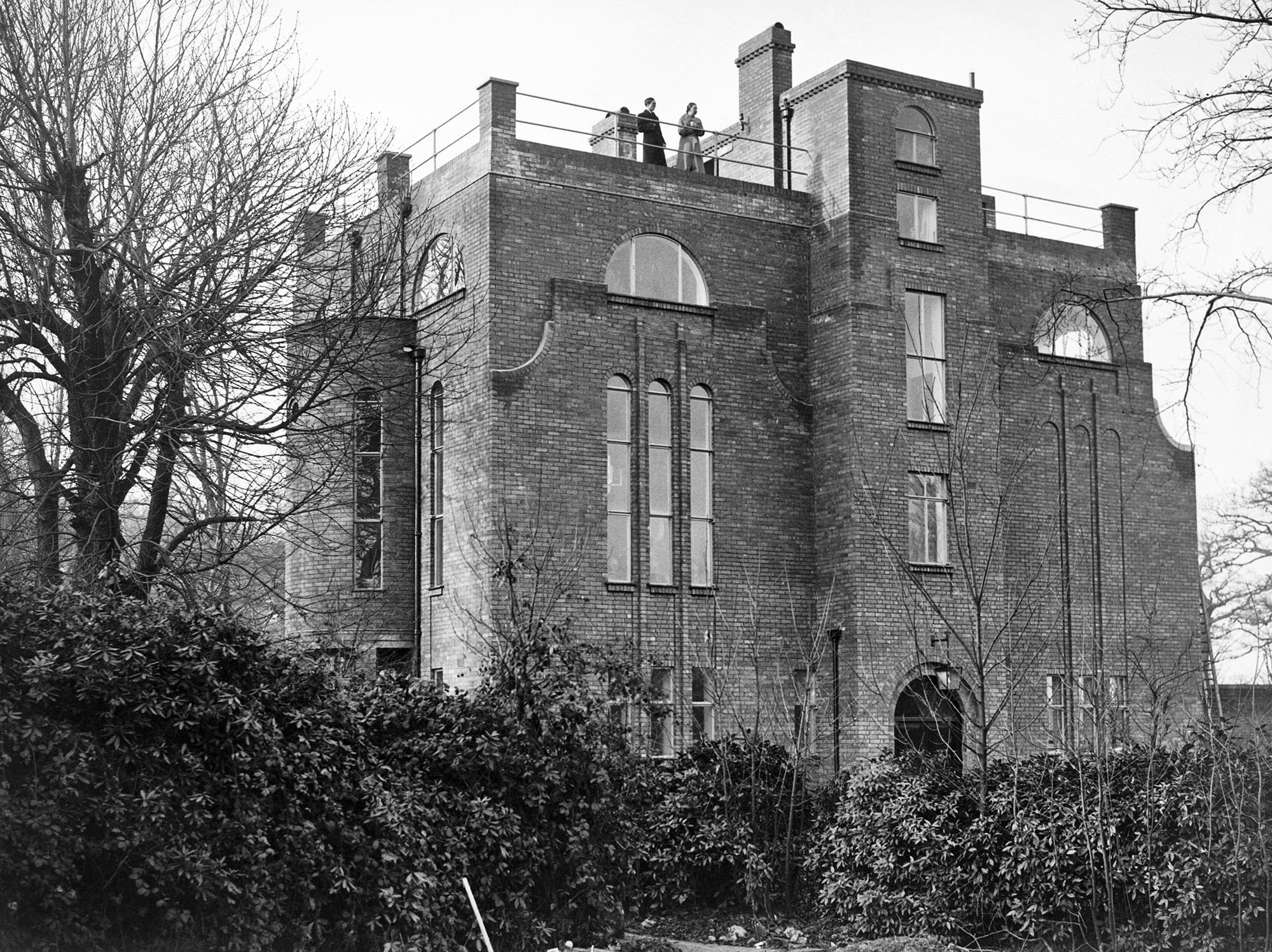 Two people standing on the roof of Dorich House
