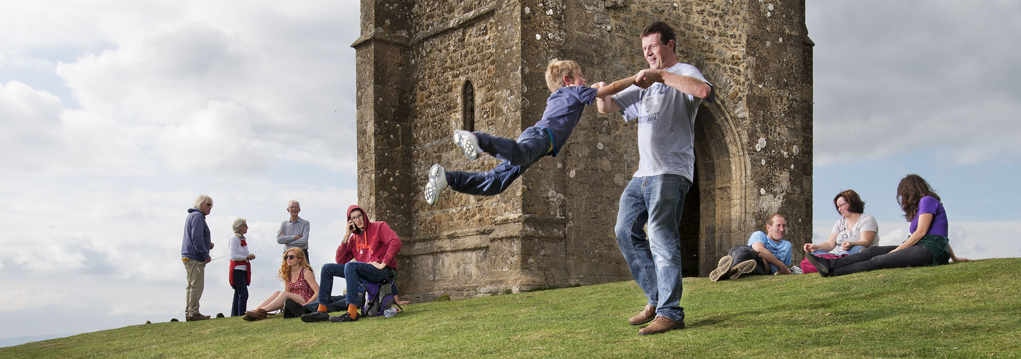 St Michael's Church, Glastonbury Tor, Glastonbury, Somerset. General view of ruins to tower of church, with people milling and enjoying the environment.