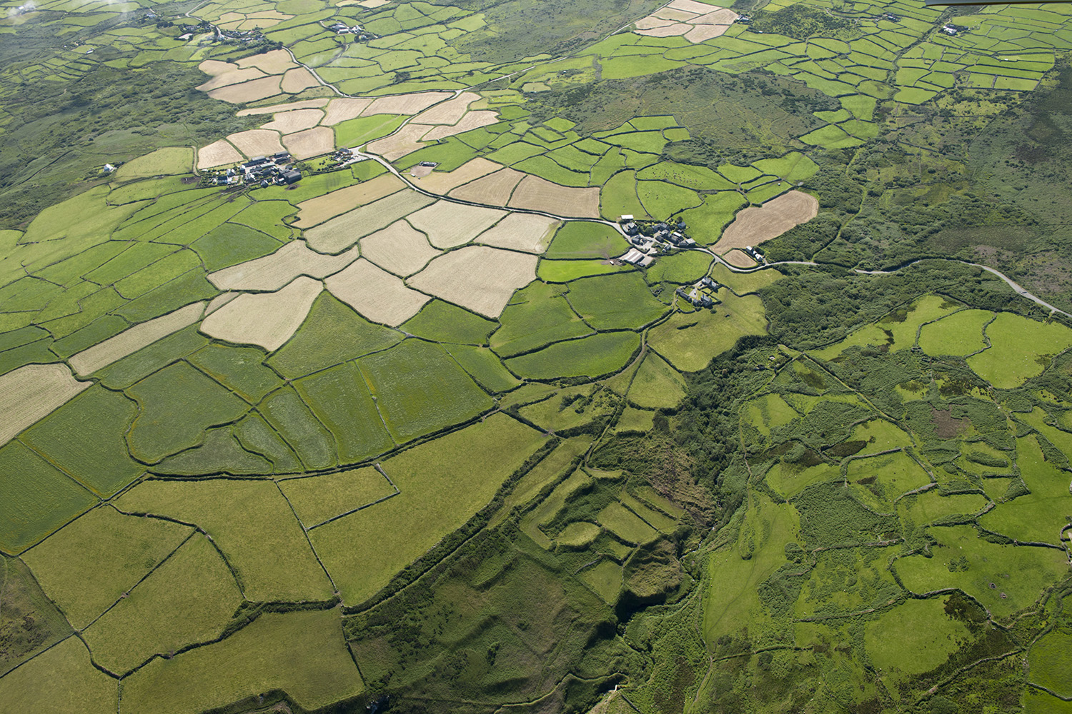 Aerial view showing a patchwork of arable fields, farms and woodland.