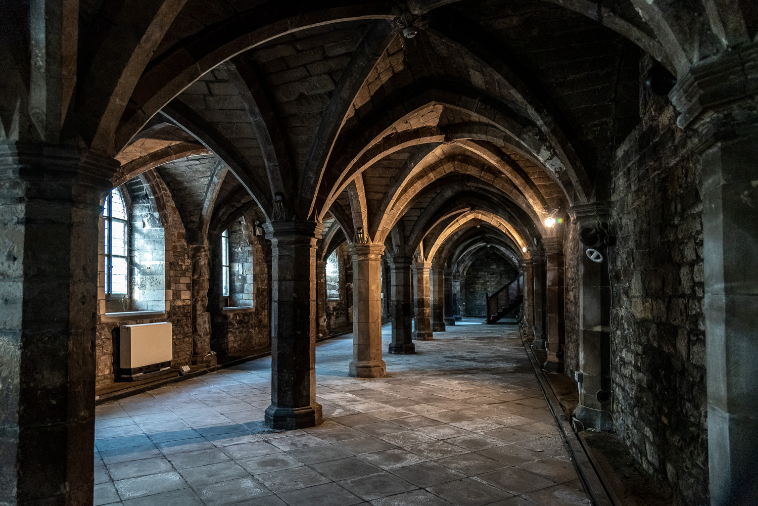 Cloisters with a stone-vaulted ceiling and arches.