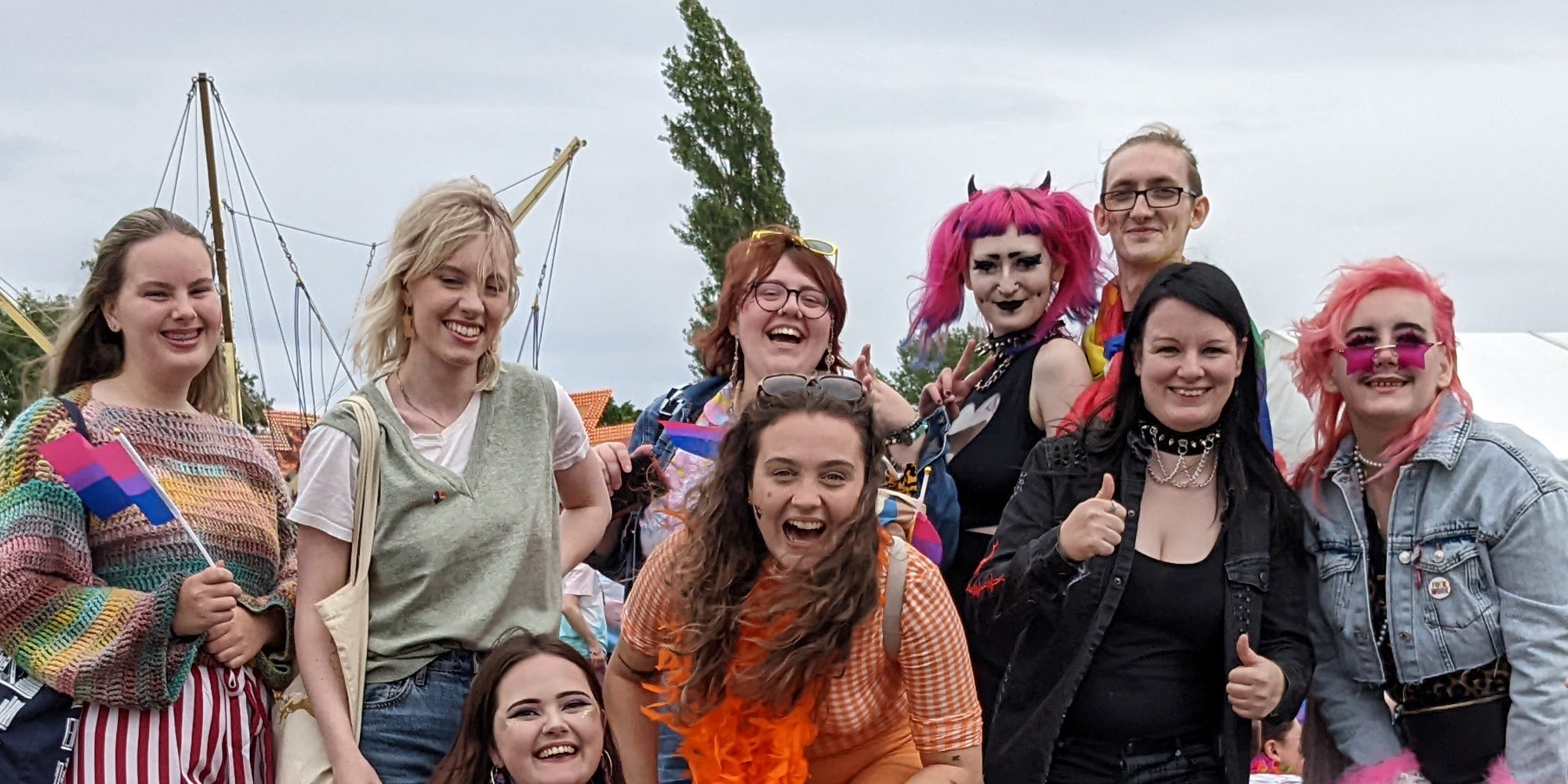 A colourful of people pose for the camera in a festival field