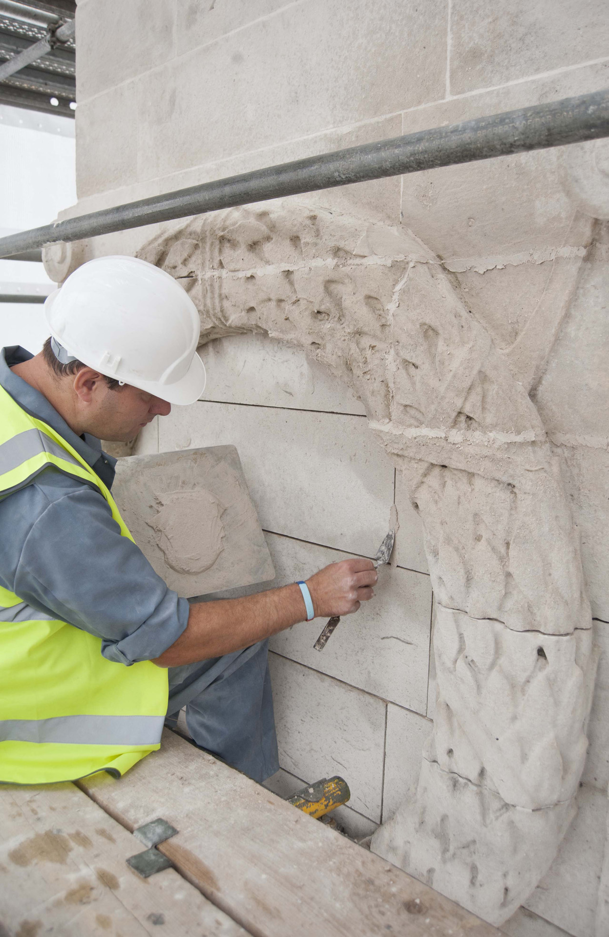 Image of a workman restoring a war memorial.