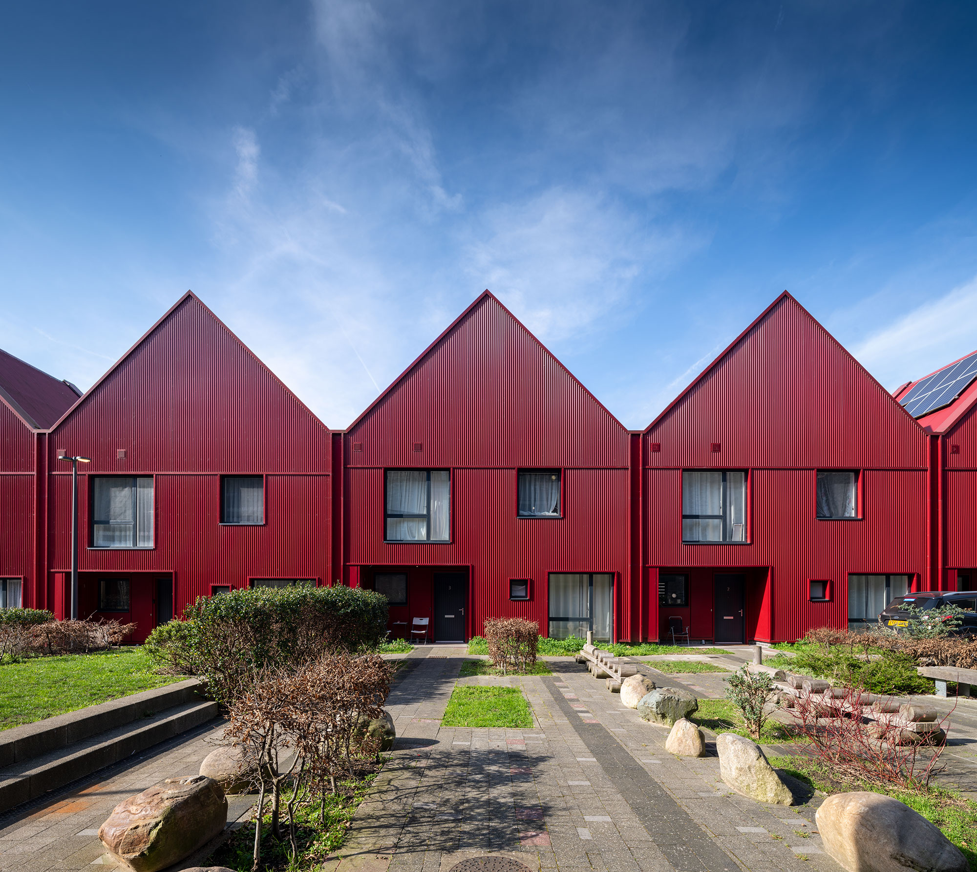 A row of modern houses, all painted red.