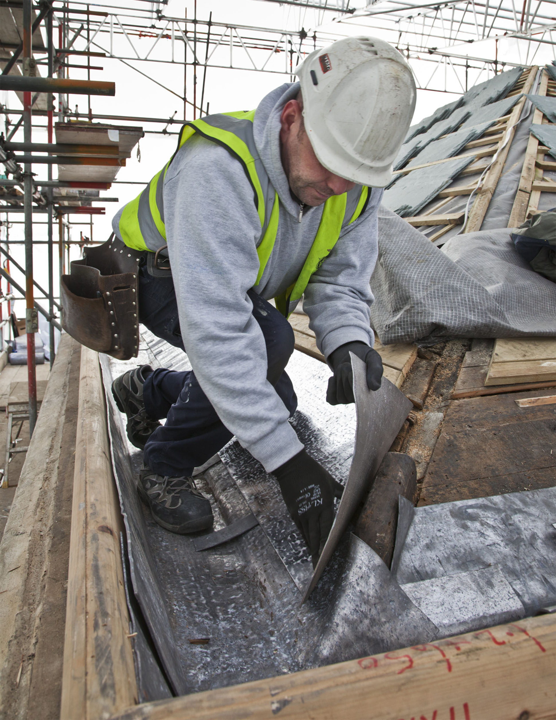 An image of a man carrying out repair work to guttering at Kenwood House.