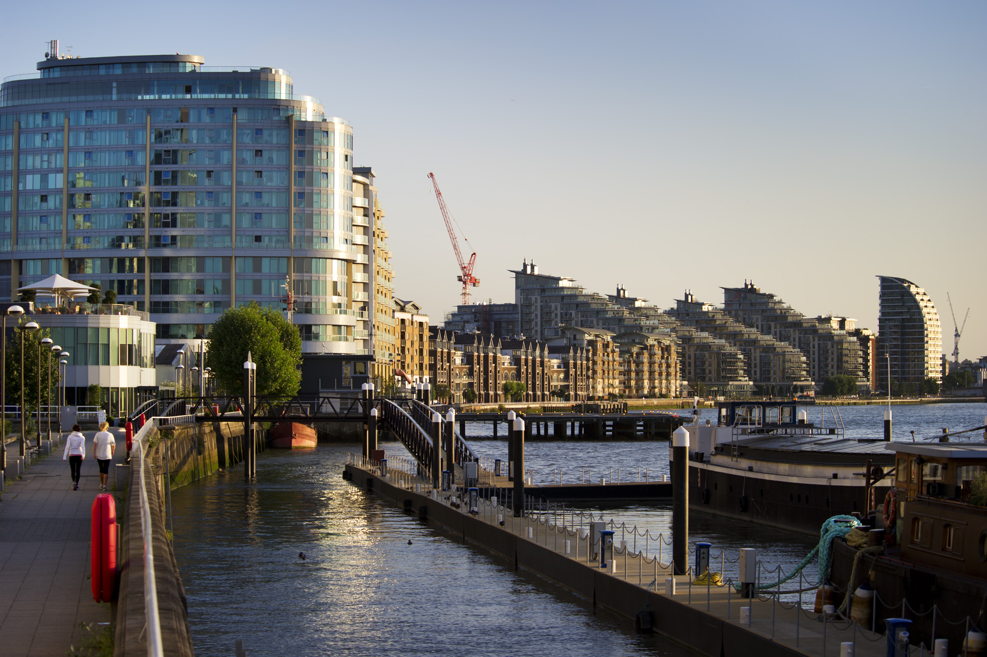 Riverside view of modern buildings under construction.
