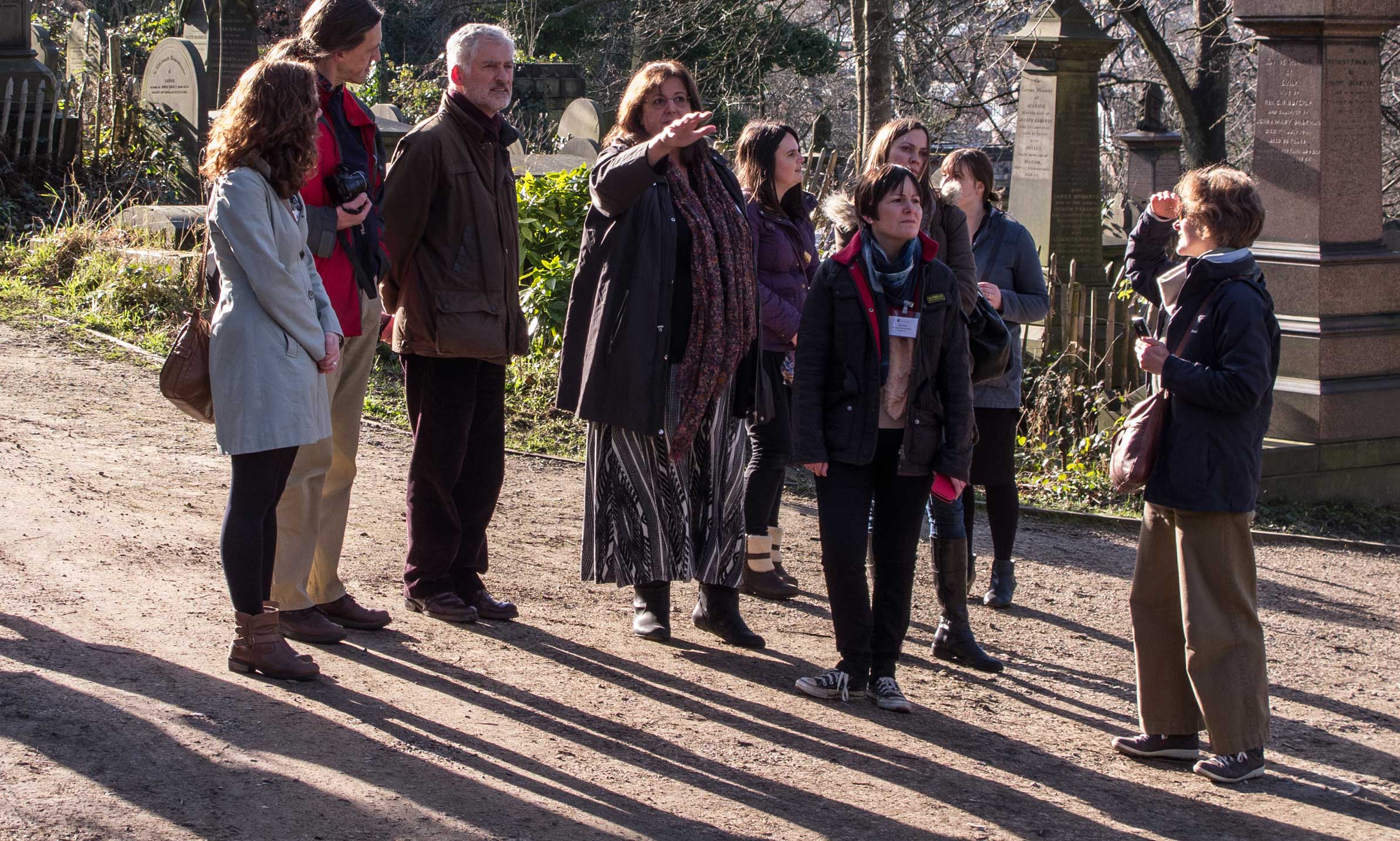 A group of people examining a historic cemetery.