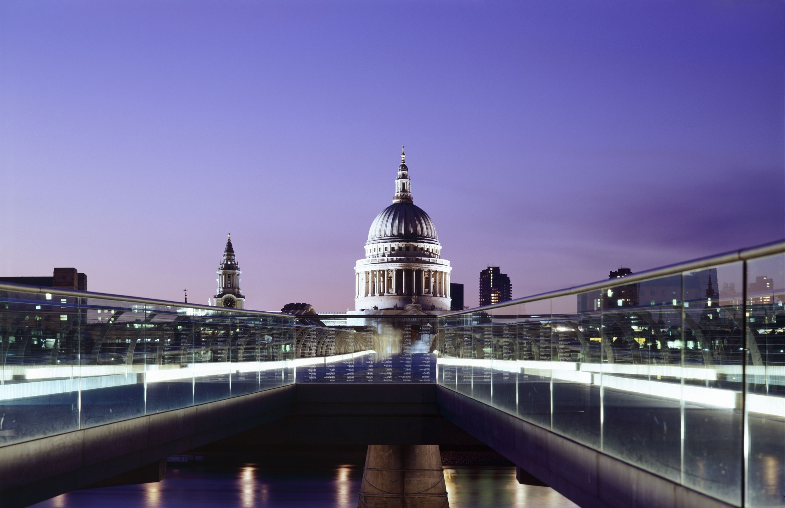 St Paul's Cathedral against a purple night sky with the London Millenium Footbridge in the foreground