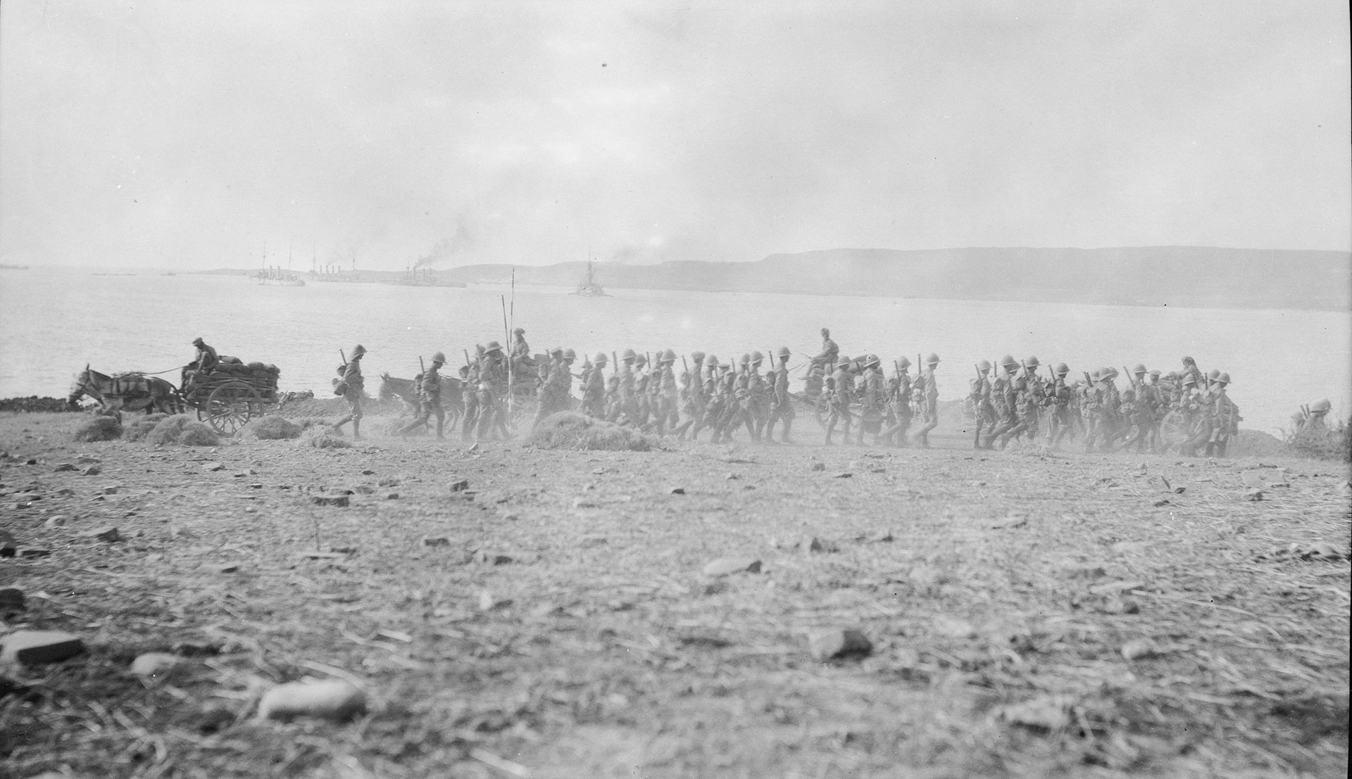 Black and white image of British troops walking on on a beach in Gallipoli, Turkey