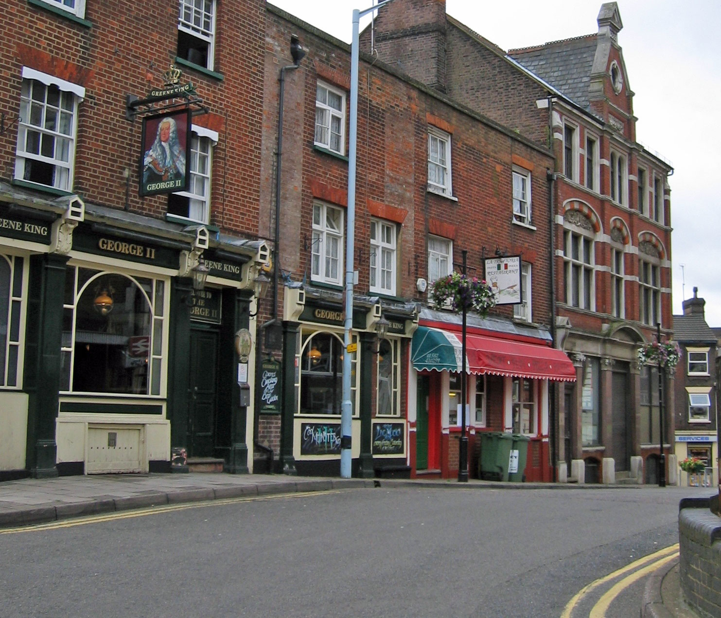 Period shop and pub fronts on a street in Plaiters Lea, Luton