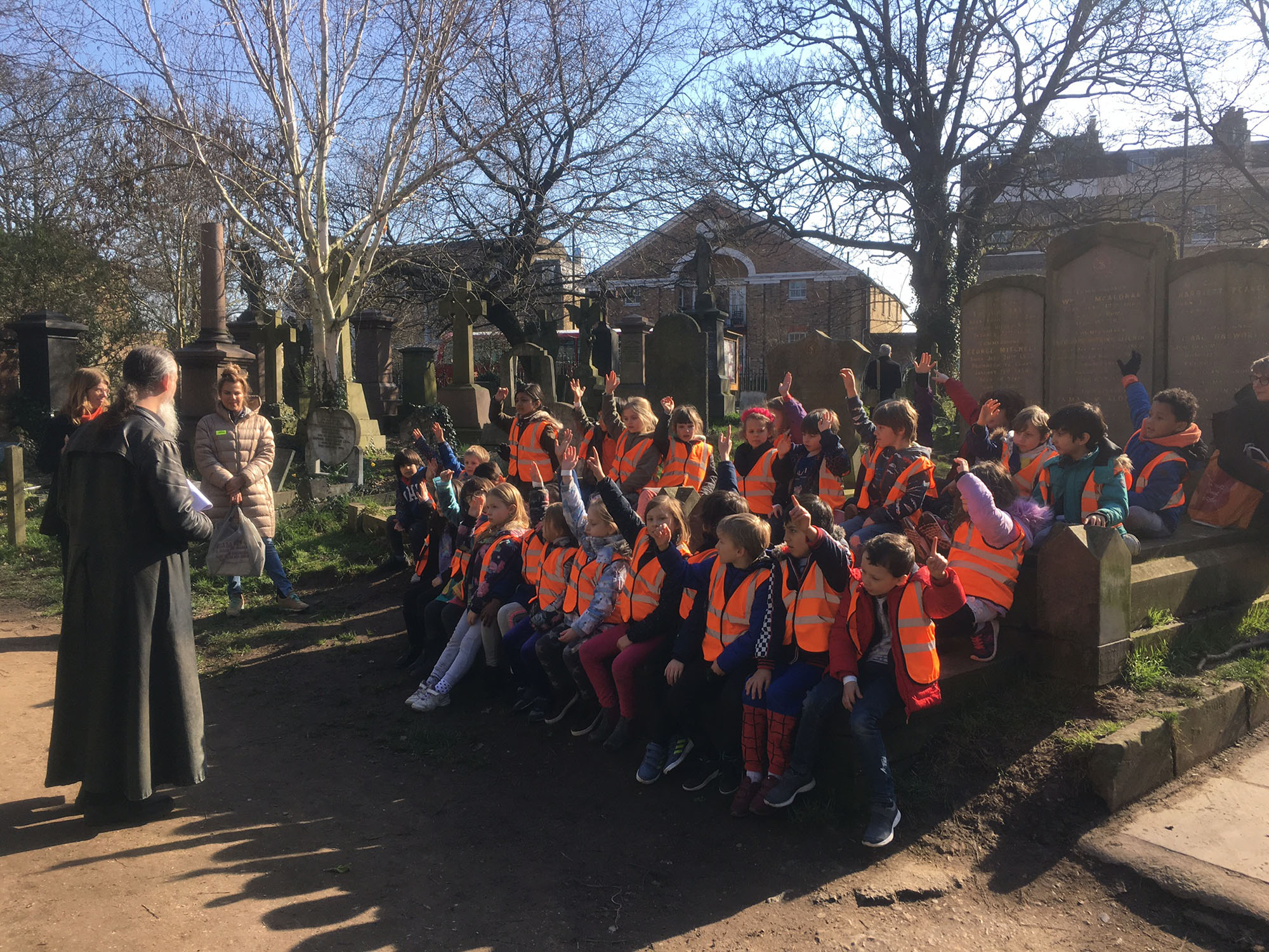 Children wearing high viz jackets gathered in Abney Park