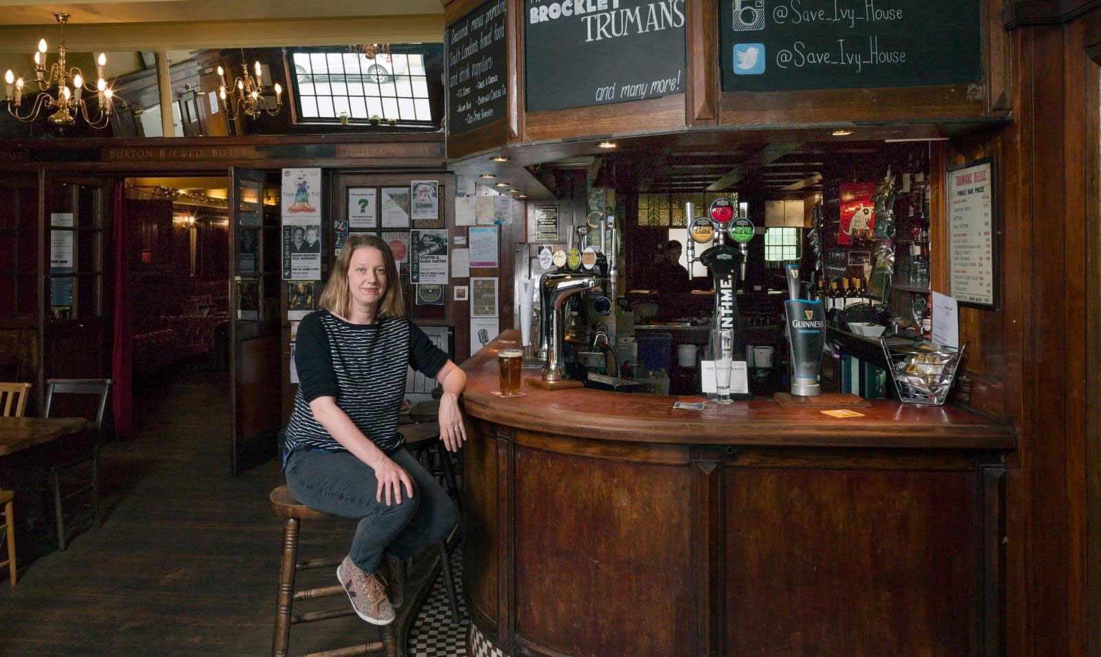 Tessa Blunden sitting at the bar of the Ivy House Community Pub of which she is co-founder. 