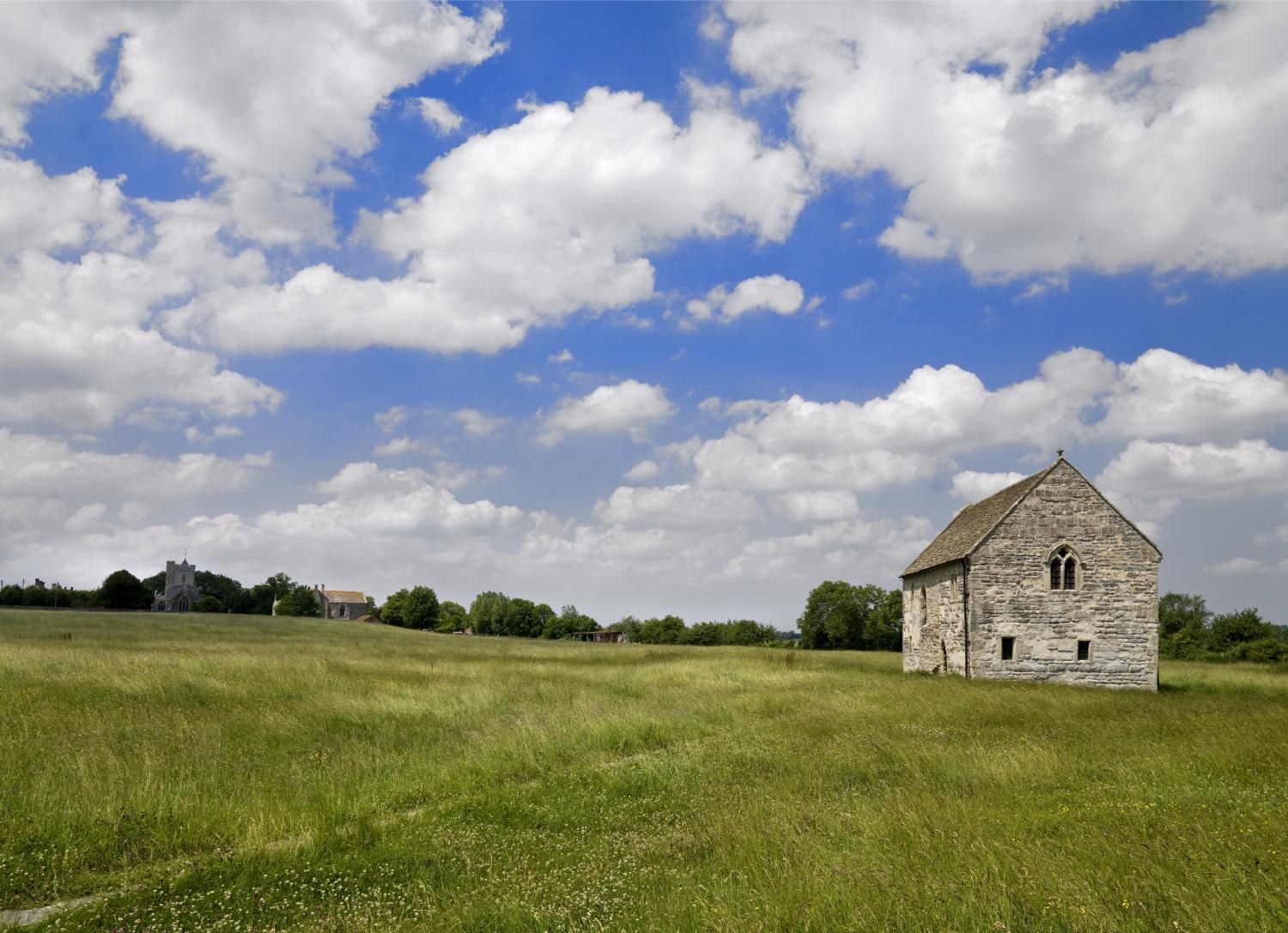 Grassland in front of an old stone building.