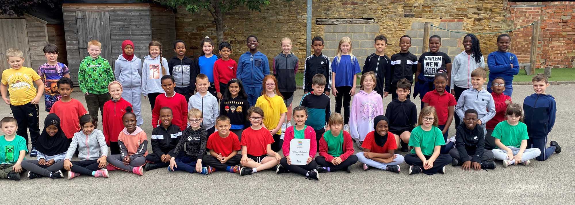 Pupils from Spring Lane Primary School, Northampton sitting in the school playground.