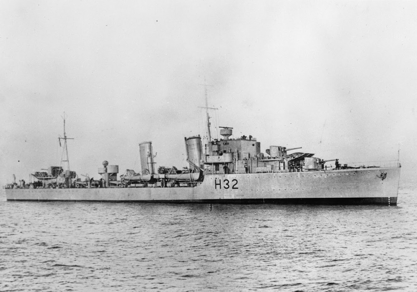 A black and white image of a Second World War destroyer ship on open water