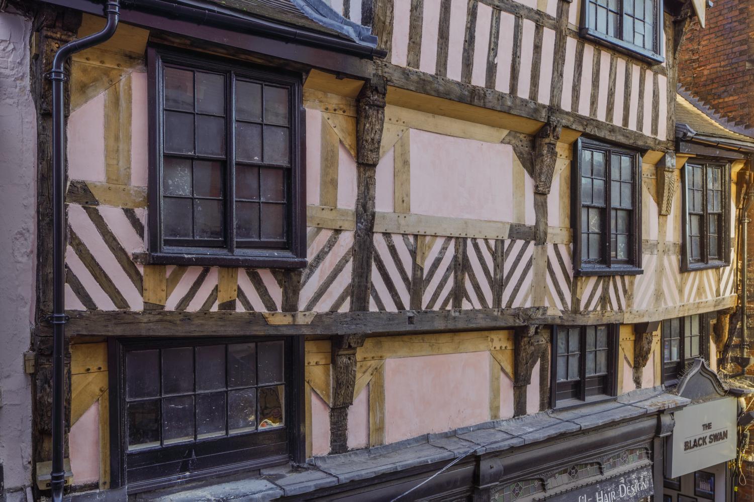 A close-up photo of the detail of a former public house's timber-framed frontage and fenestration