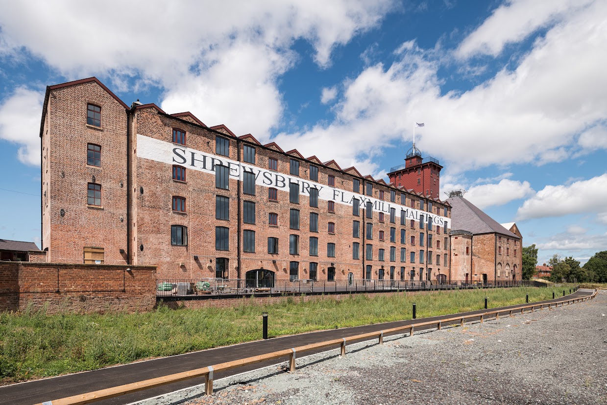 A large 5-storey brick warehouse with  a sign reading Shrewsbury Flaxmill Maltings on the side