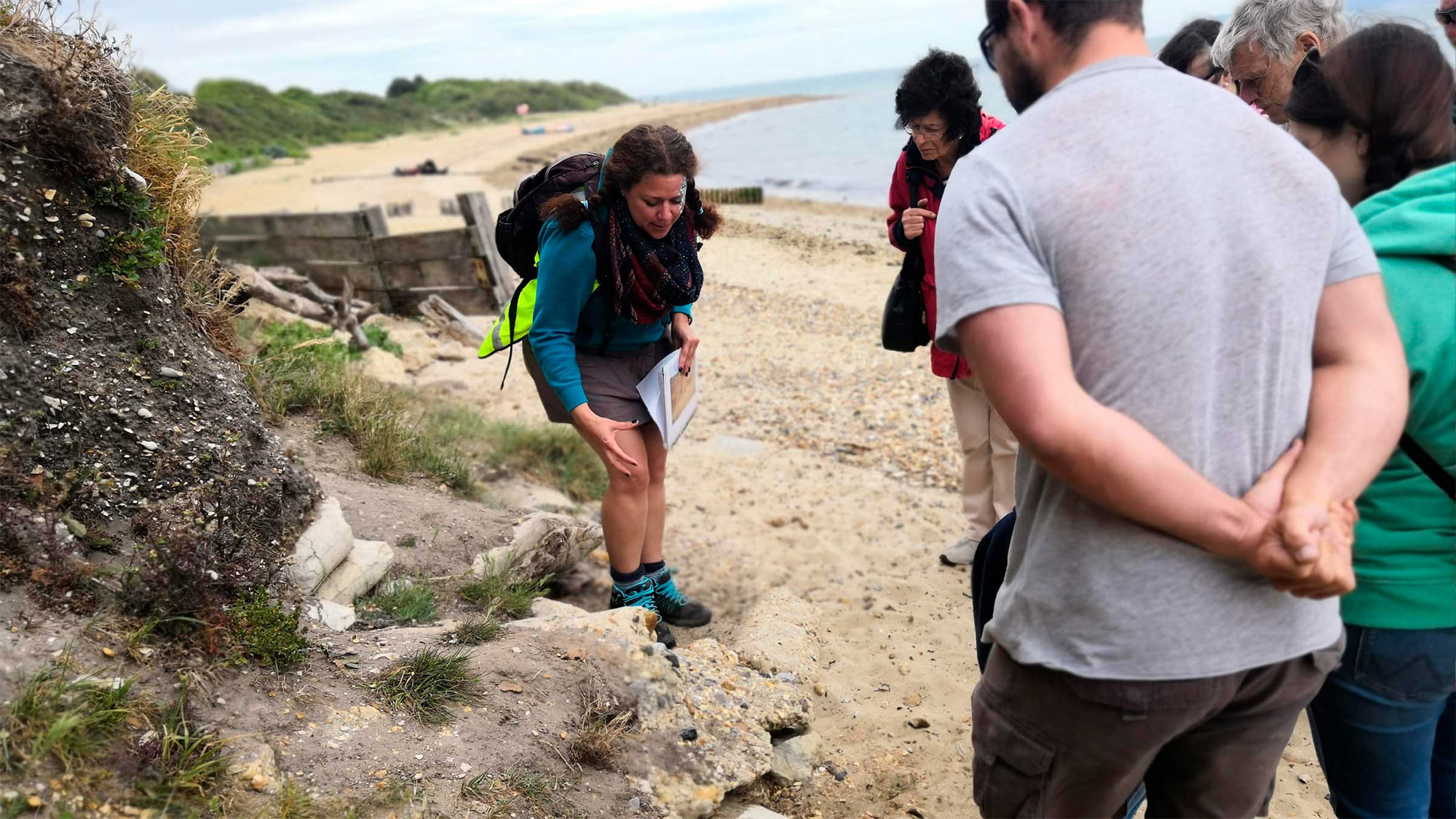 People examining a structure on a beach.