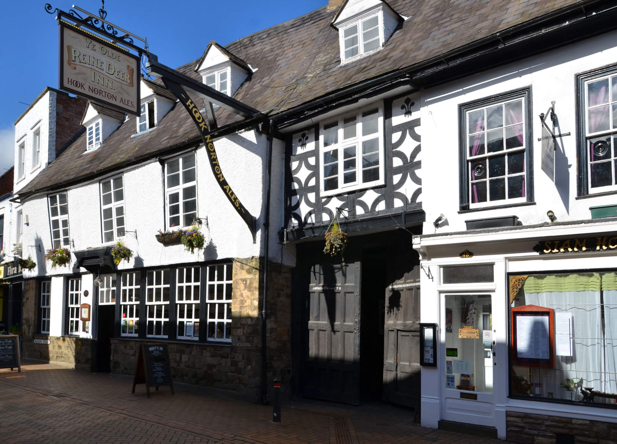 A timber-framed inn with a carriage entrance.