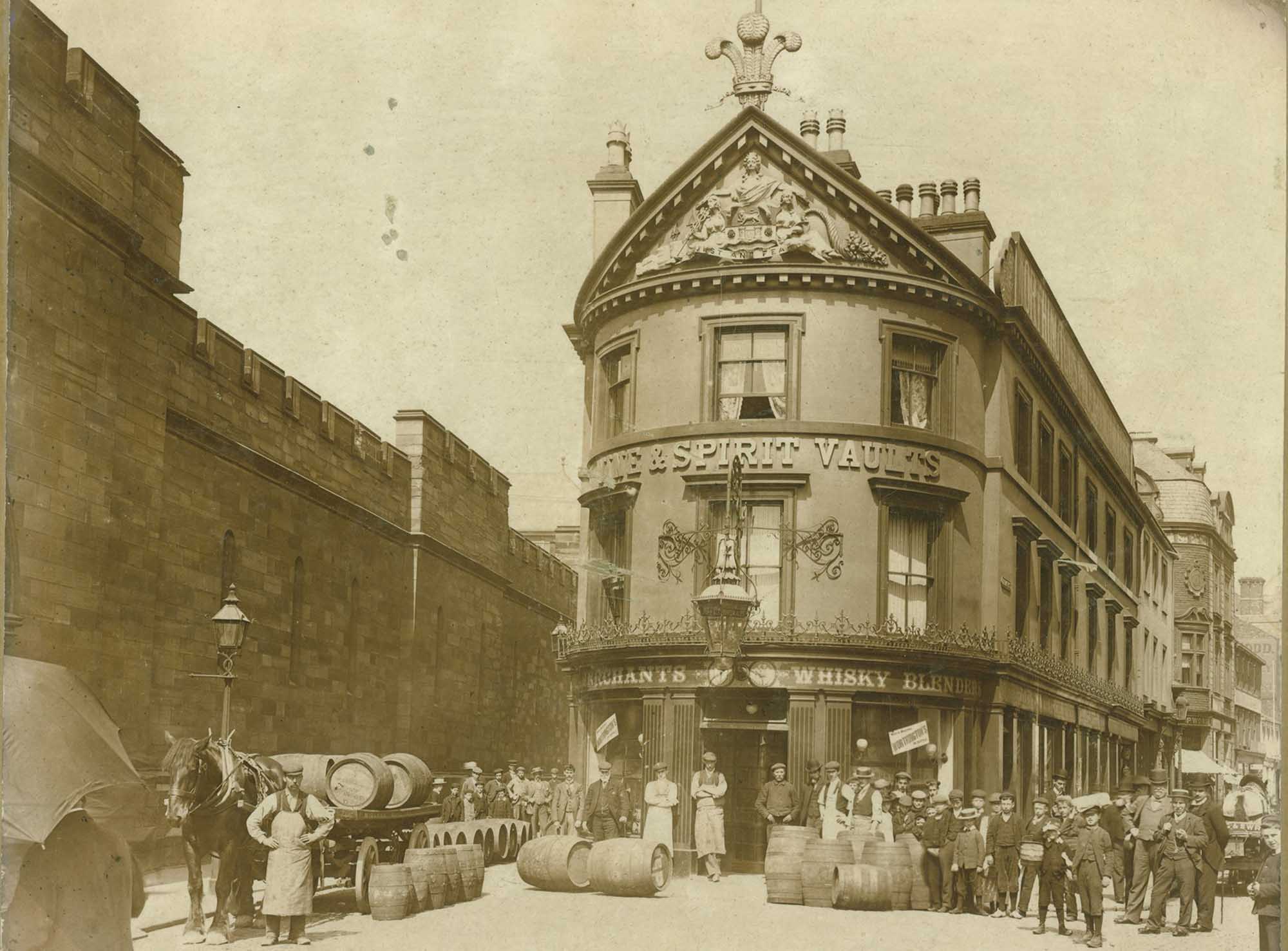 Exterior of the Spirit Vaults public house (later renamed Carlistle Arms) with a delivery of barrels being unloaded from a horse-drawn wagon.