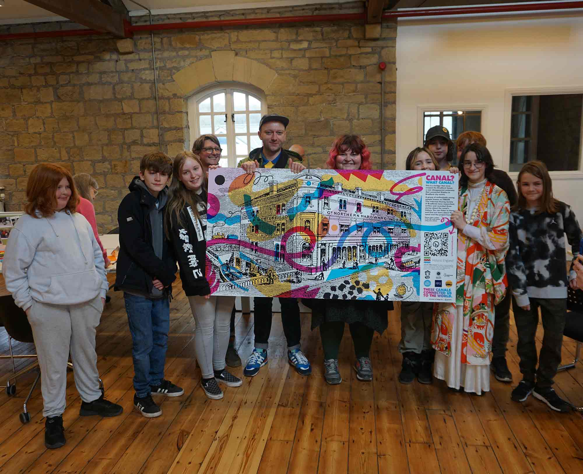 Group of people holding a large banner depicting the role of canals