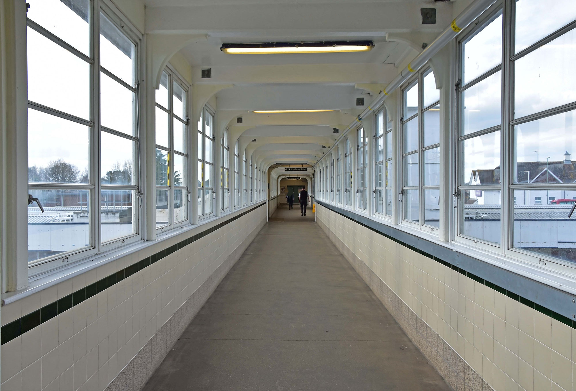 View of people in the distance walking down a long walkway.