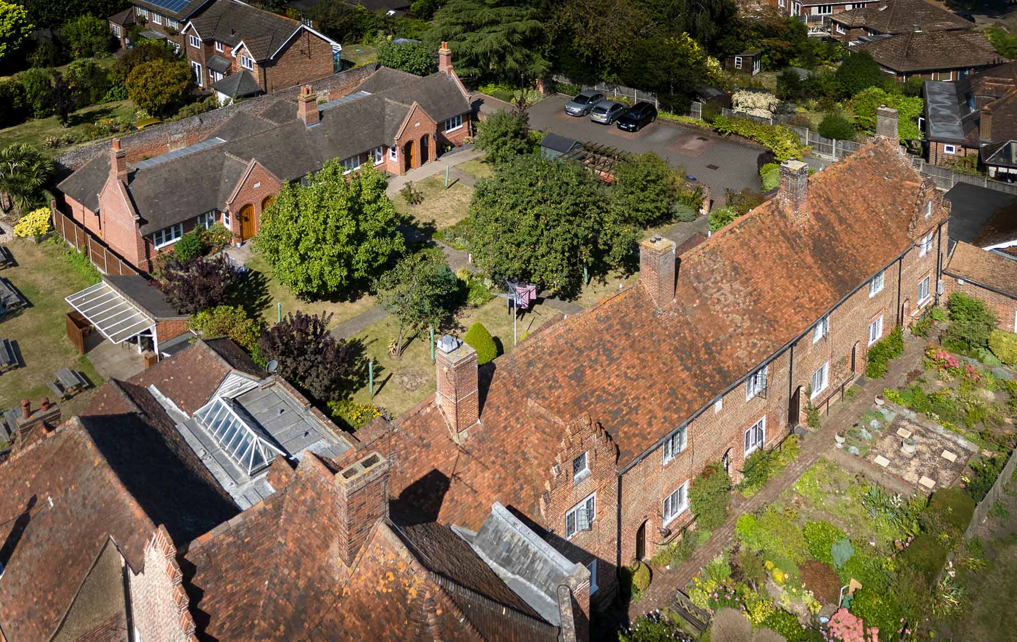 Oblique aerial view from the south-west showing the rooftops and south-east elevation of Manwood's Hospital, with 1-4 Manwood Orchard Close in the background.