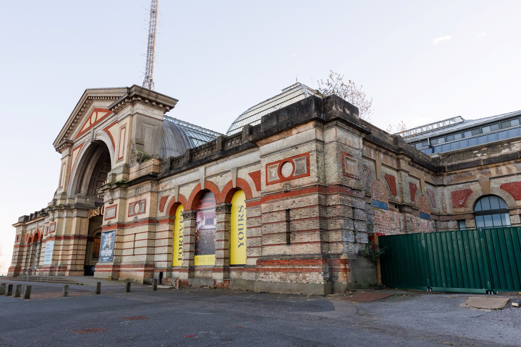 A photograph showing one elevation of a large building with decorative brickwork and arches.
