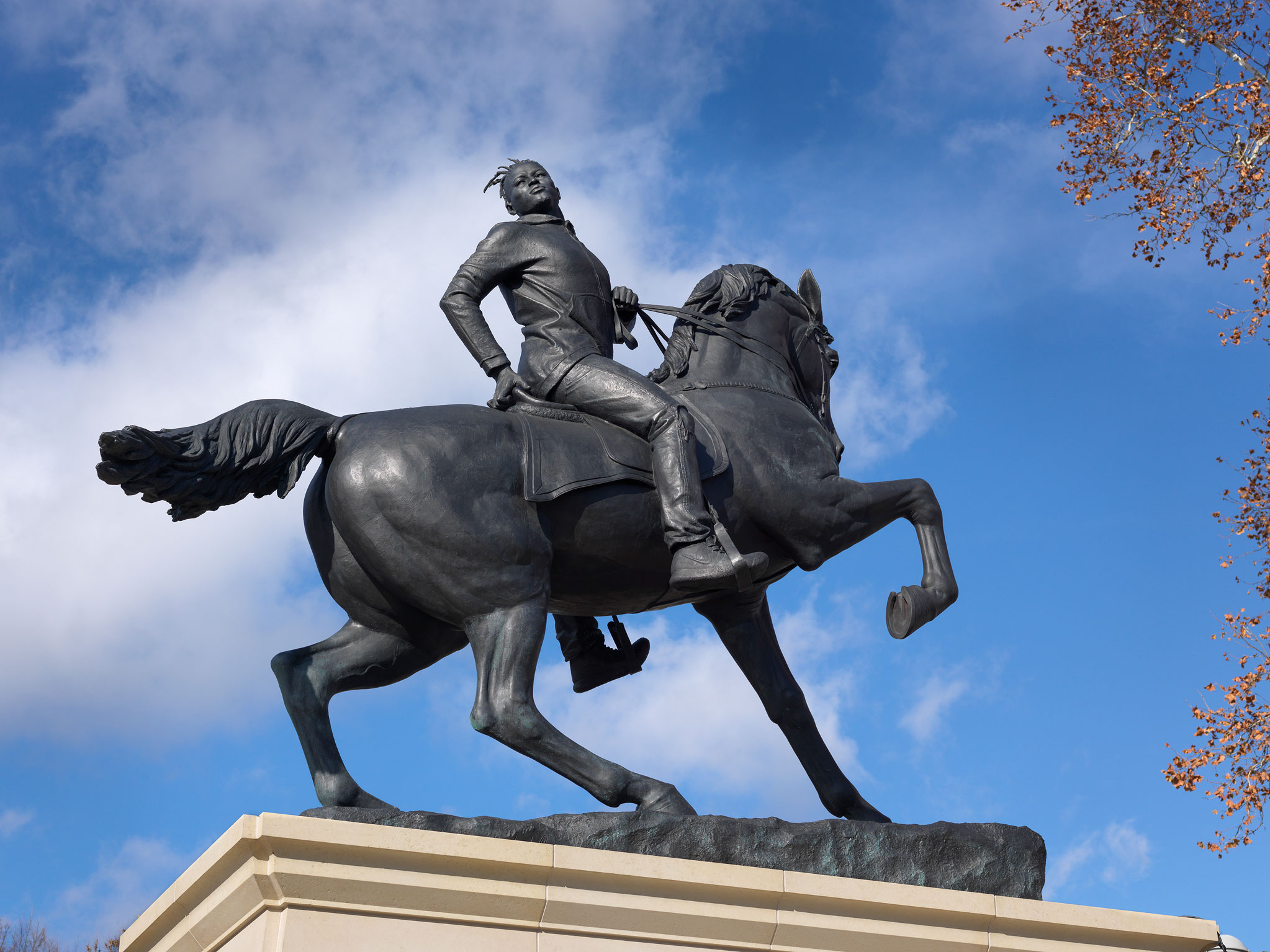 A statue of a young African American man on horseback dressed in modern street-wear.