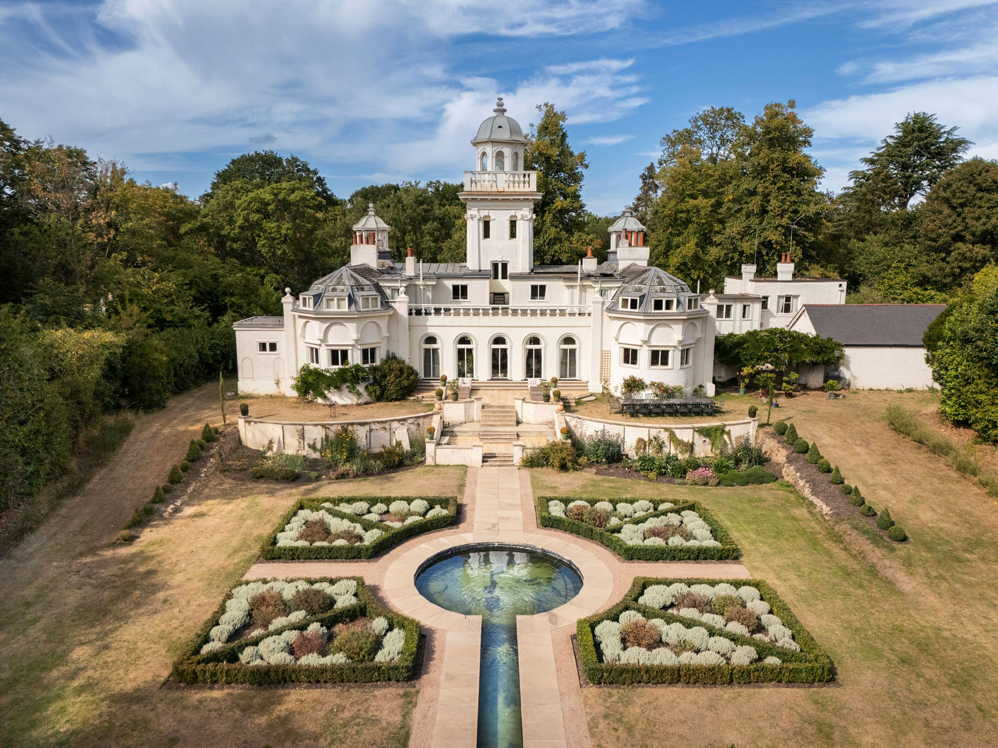 Lawned garden with central circular water feature and designed planted beds